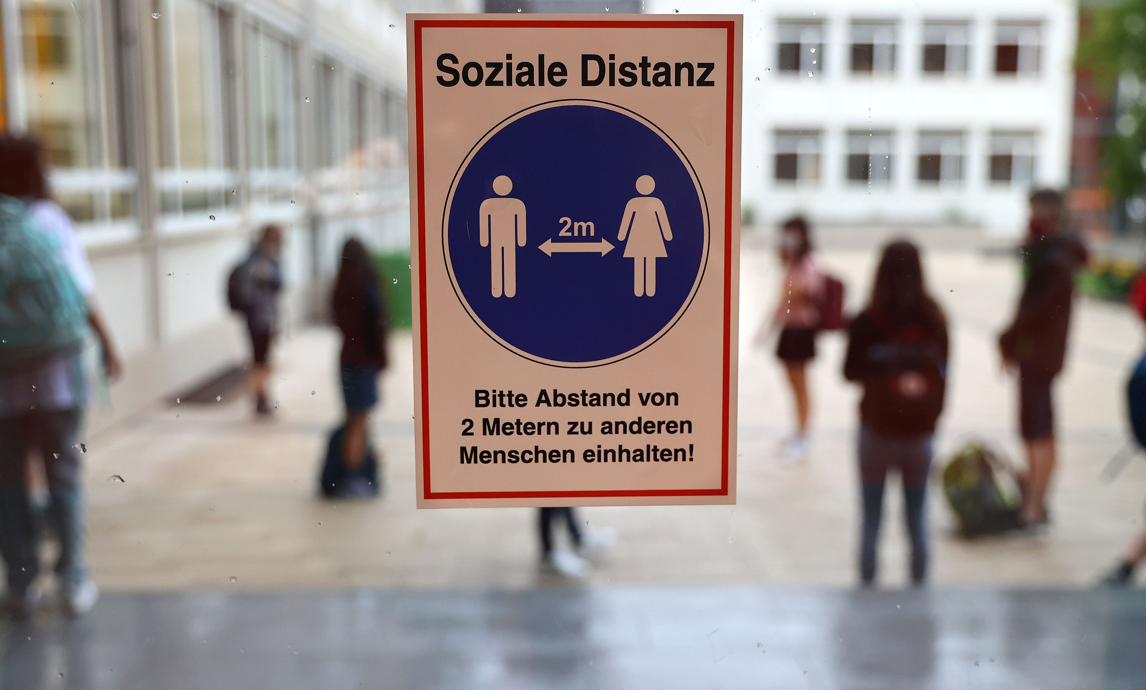 Una señal recuerda el distanciamiento social en un colegio de Alemania