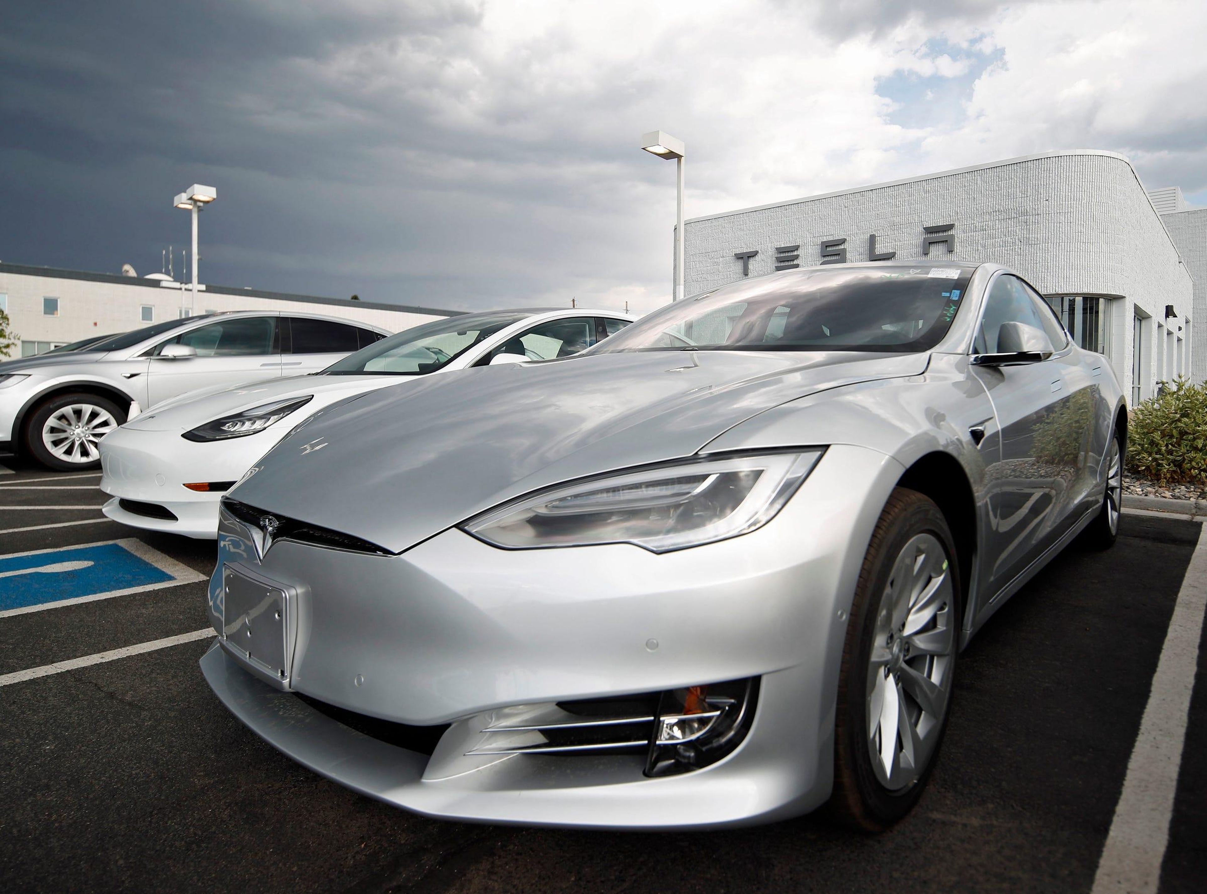 In this Sunday, July 8, 2018, photograph, 2018 Model 3 sedans sit on display outside a Tesla showroom in Littleton, Colo. AP Photo/David Zalubowski