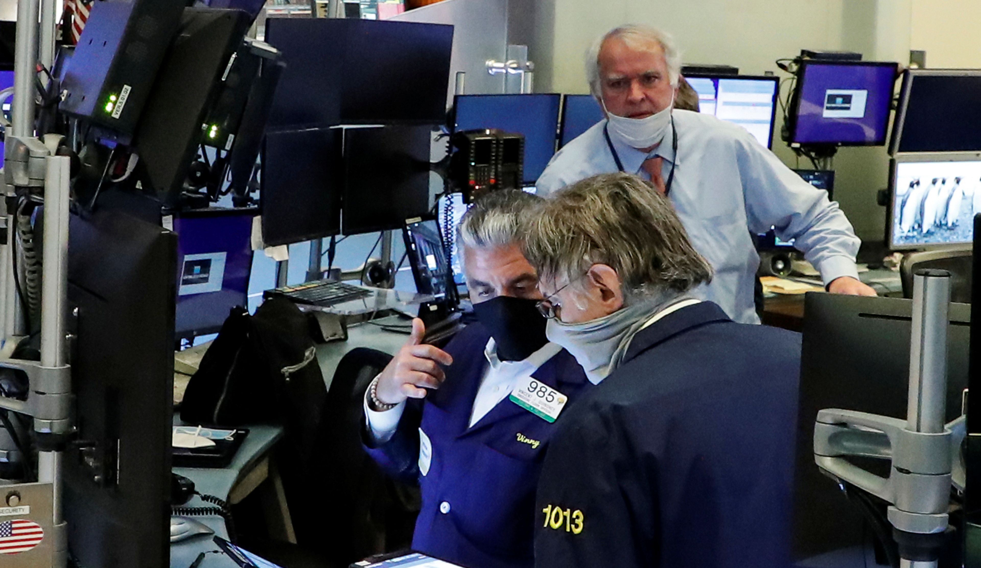 Traders con mascarilla en Wall Street
