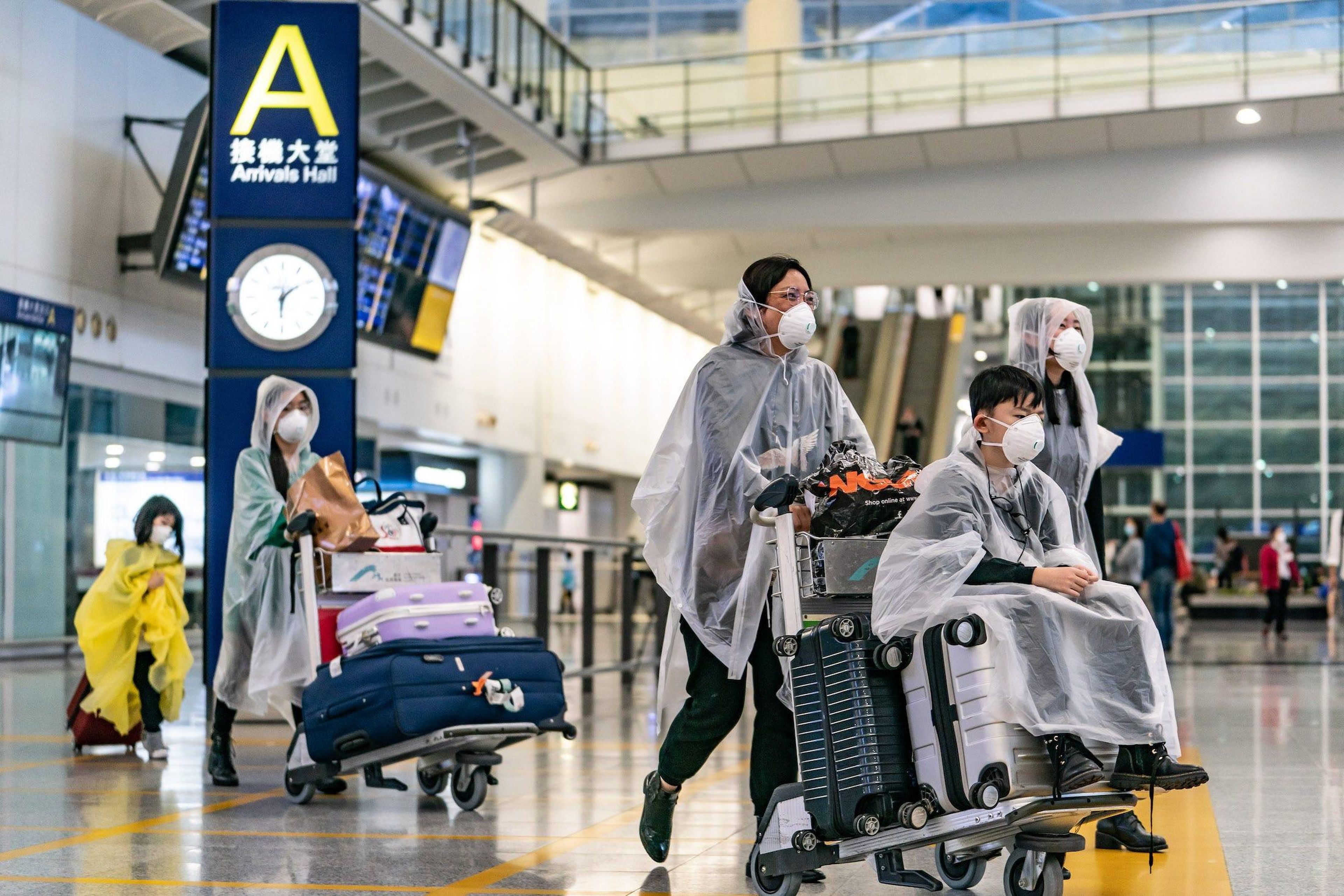 Travelers wearing protective equipment as a precautionary measure against COVID-19 enter the arrivals hall at Hong Kong International Airport on March 17, 2020 in Hong Kong, China. Anthony Kwan/Getty Images