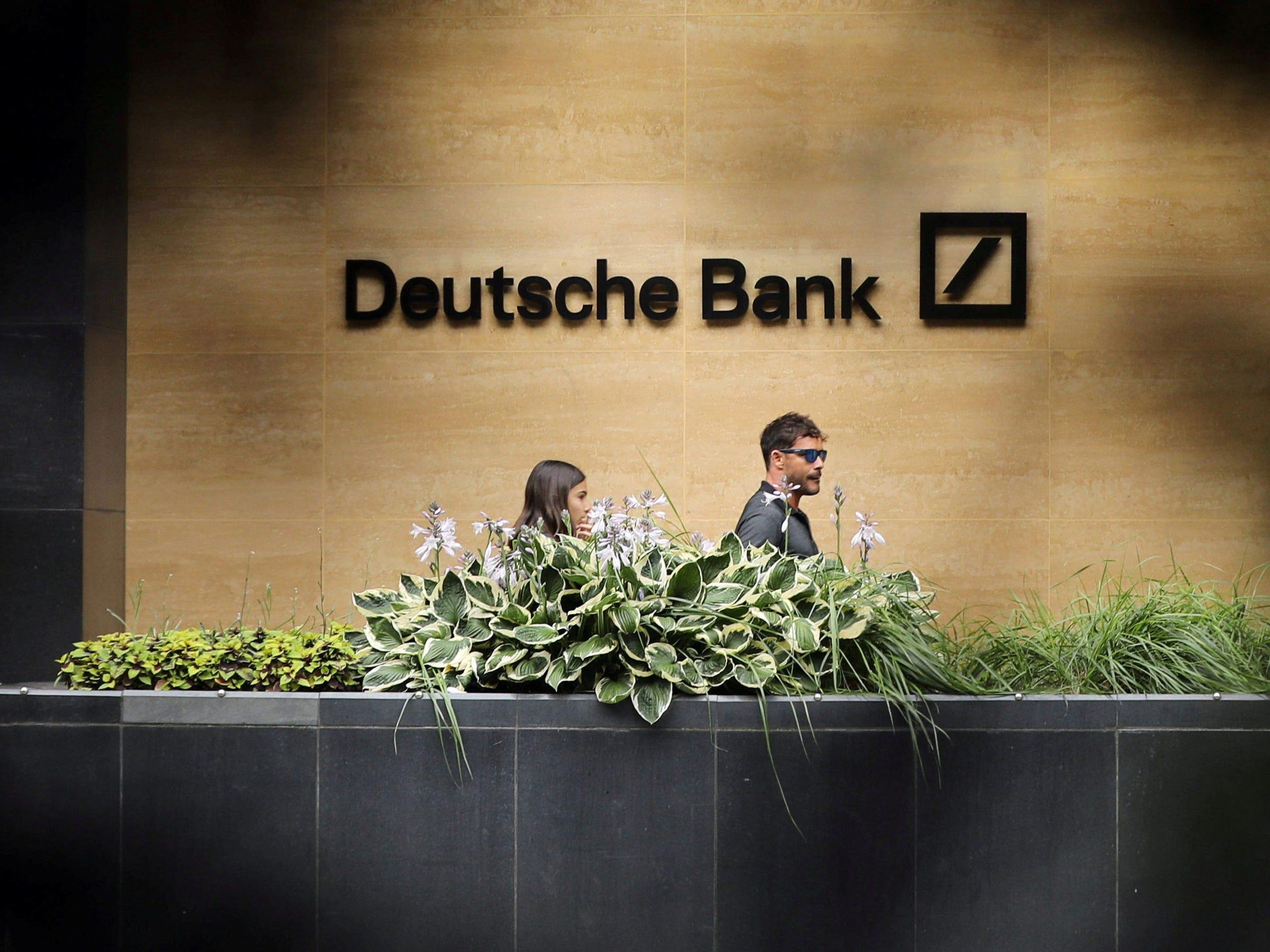 FILE PHOTO: People walk past a Deutsche Bank office in London. Reuters