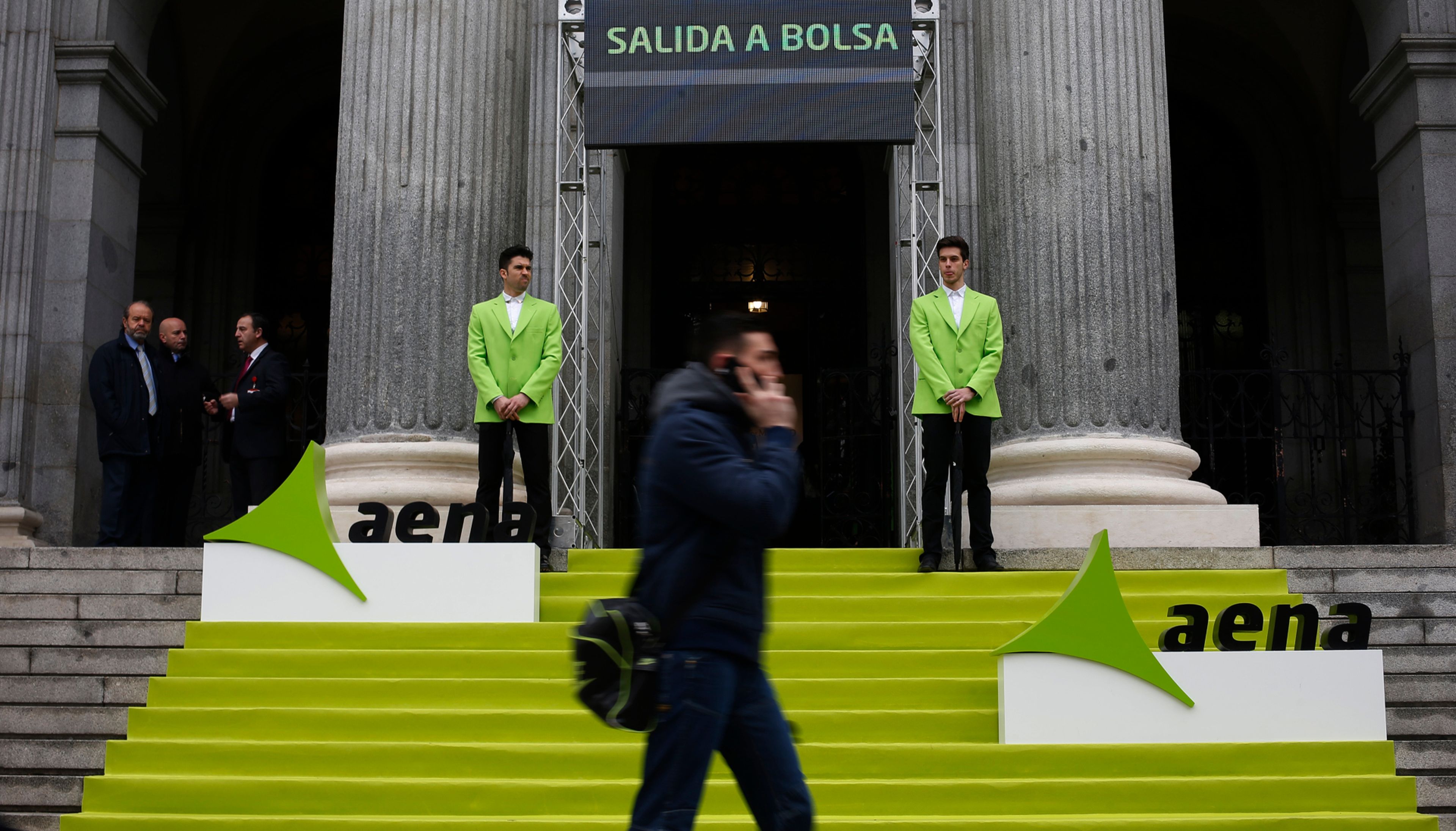Un hombre pasa ante la Bolsa de Madrid durante el debut de Aena en el Ibex 35