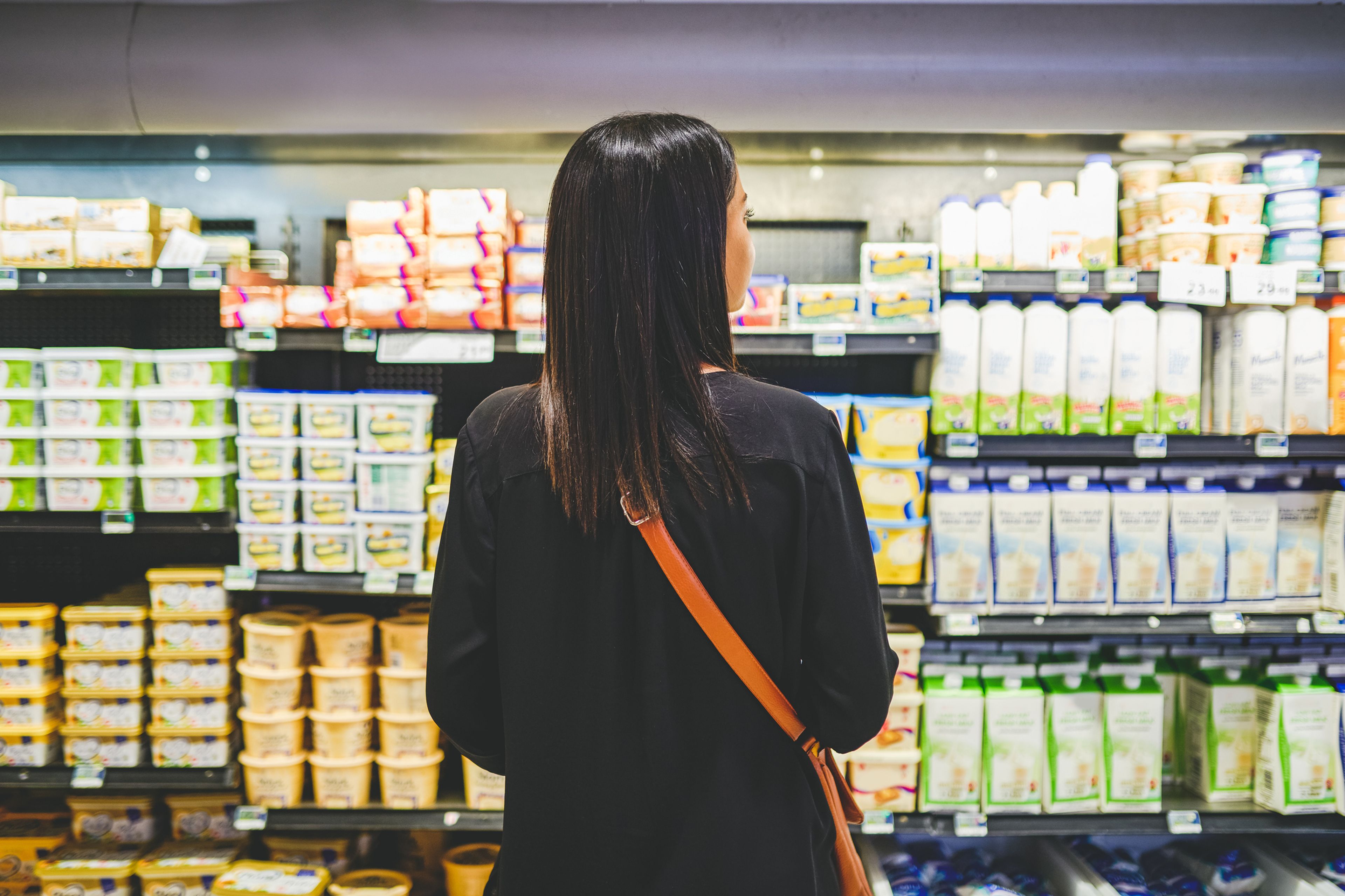 mujer en supermercado comprando mantequilla