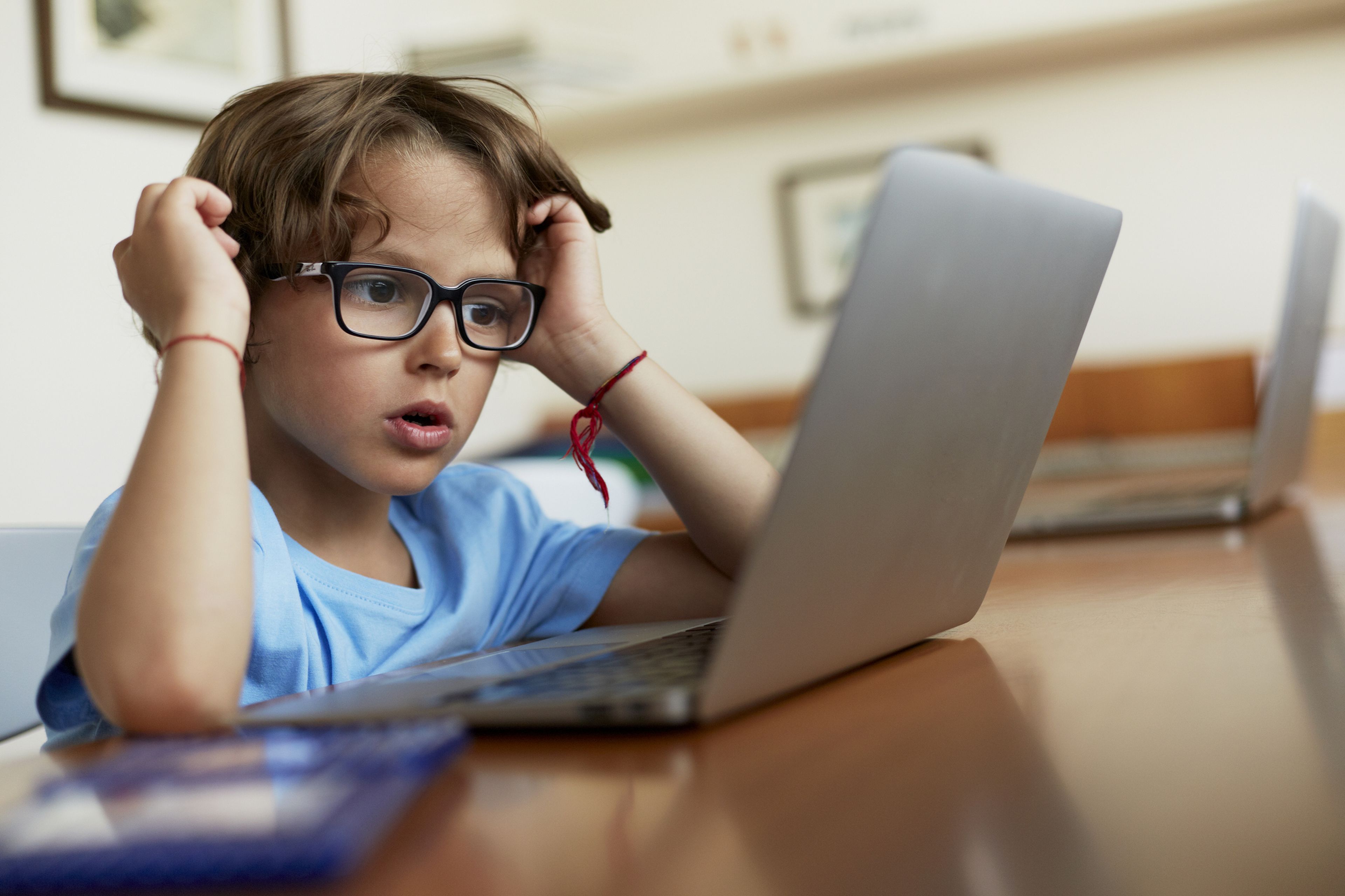 Niño con gafas en el ordenador.