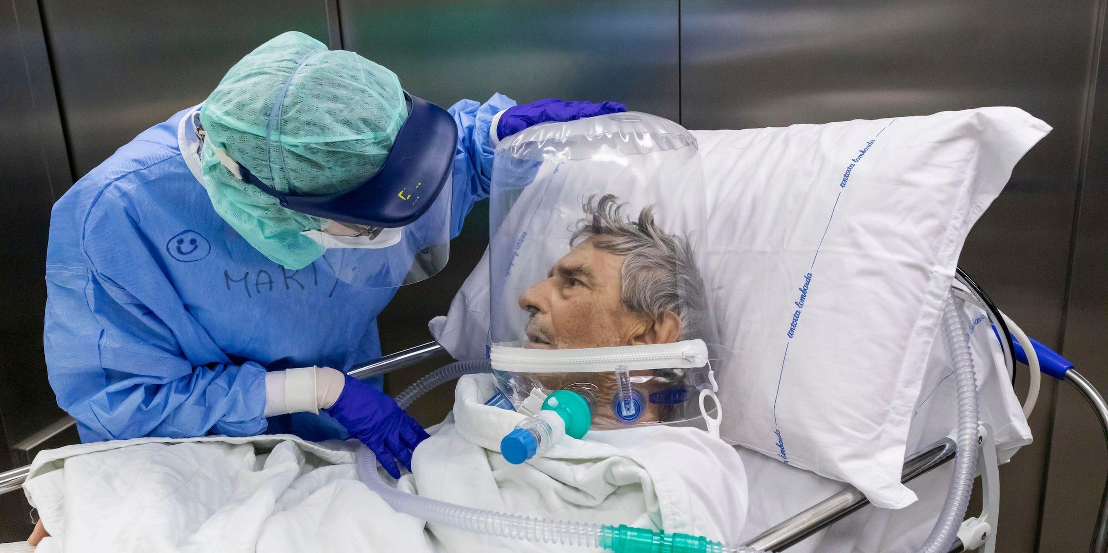 Una enfermera atiende a un paciente de COVID-19 que lleva un casco CPAP mientras es trasladado de la Unidad de Cuidados Intensivos (UCI) del Hospital Papa Juan XXIII el 7 de abril de 2020 en Bérgamo, Italia.