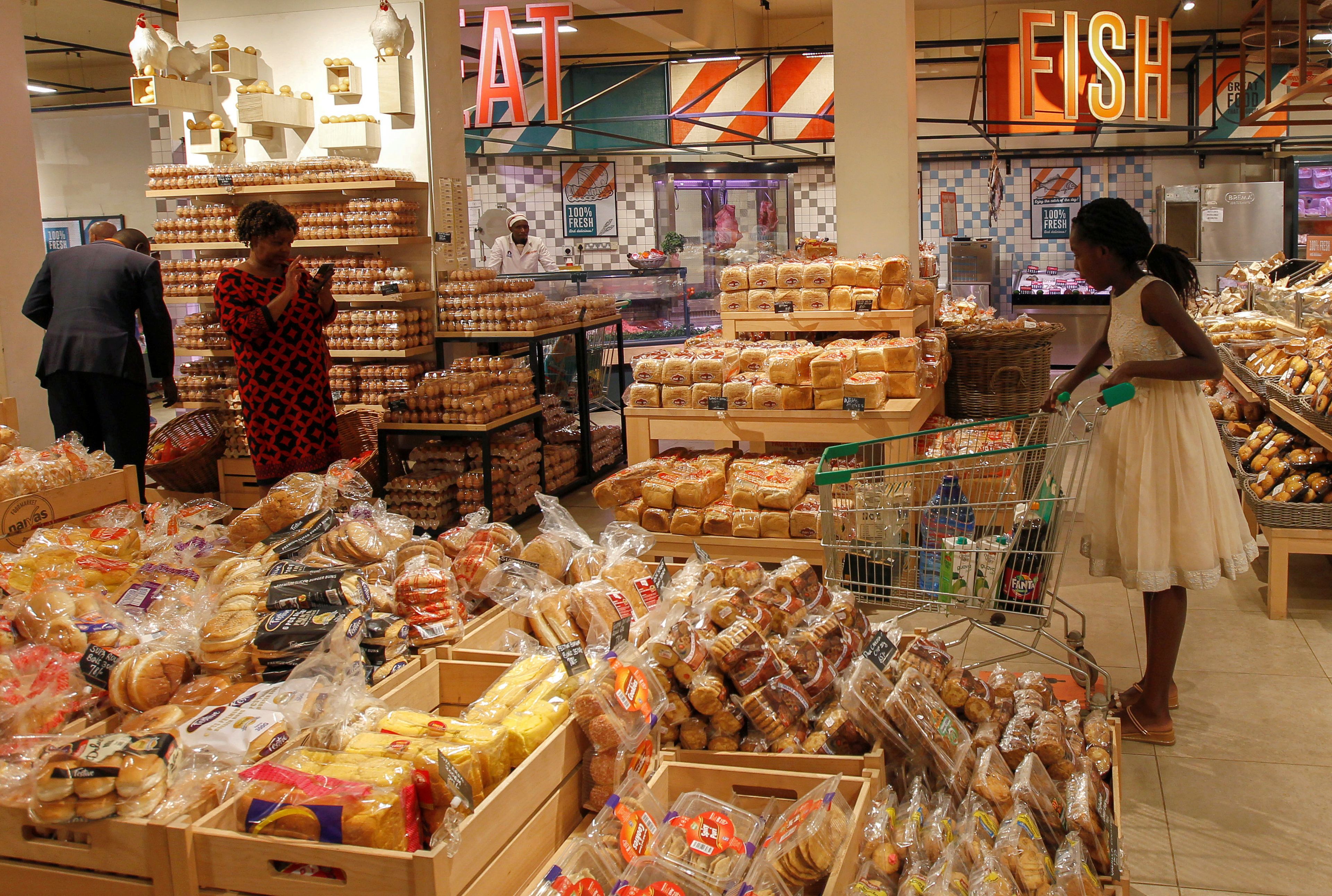 personas en el supermercado comprando pan