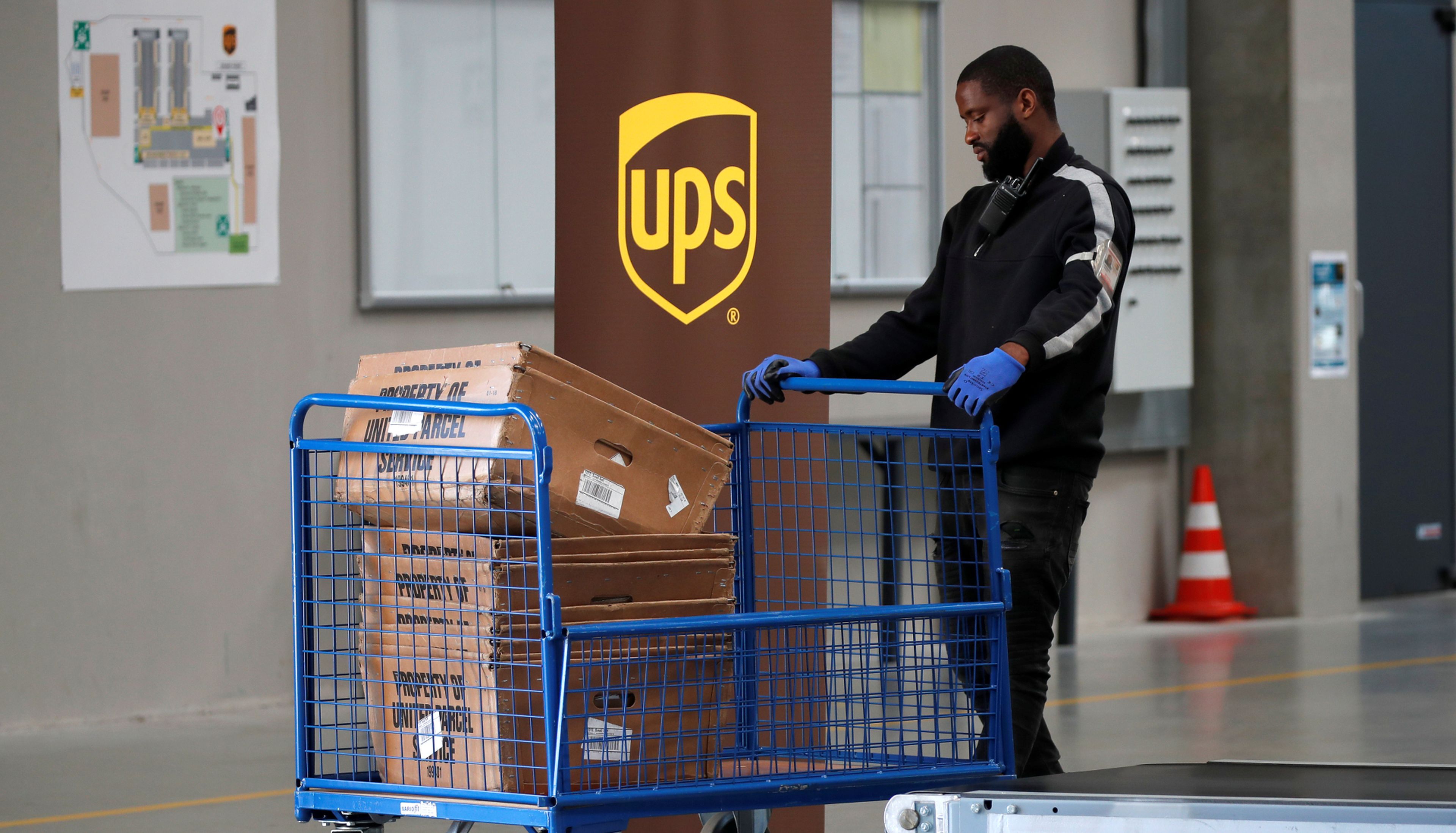 Un trabajador de UPS transporta paquetes en un almacén de la compañía