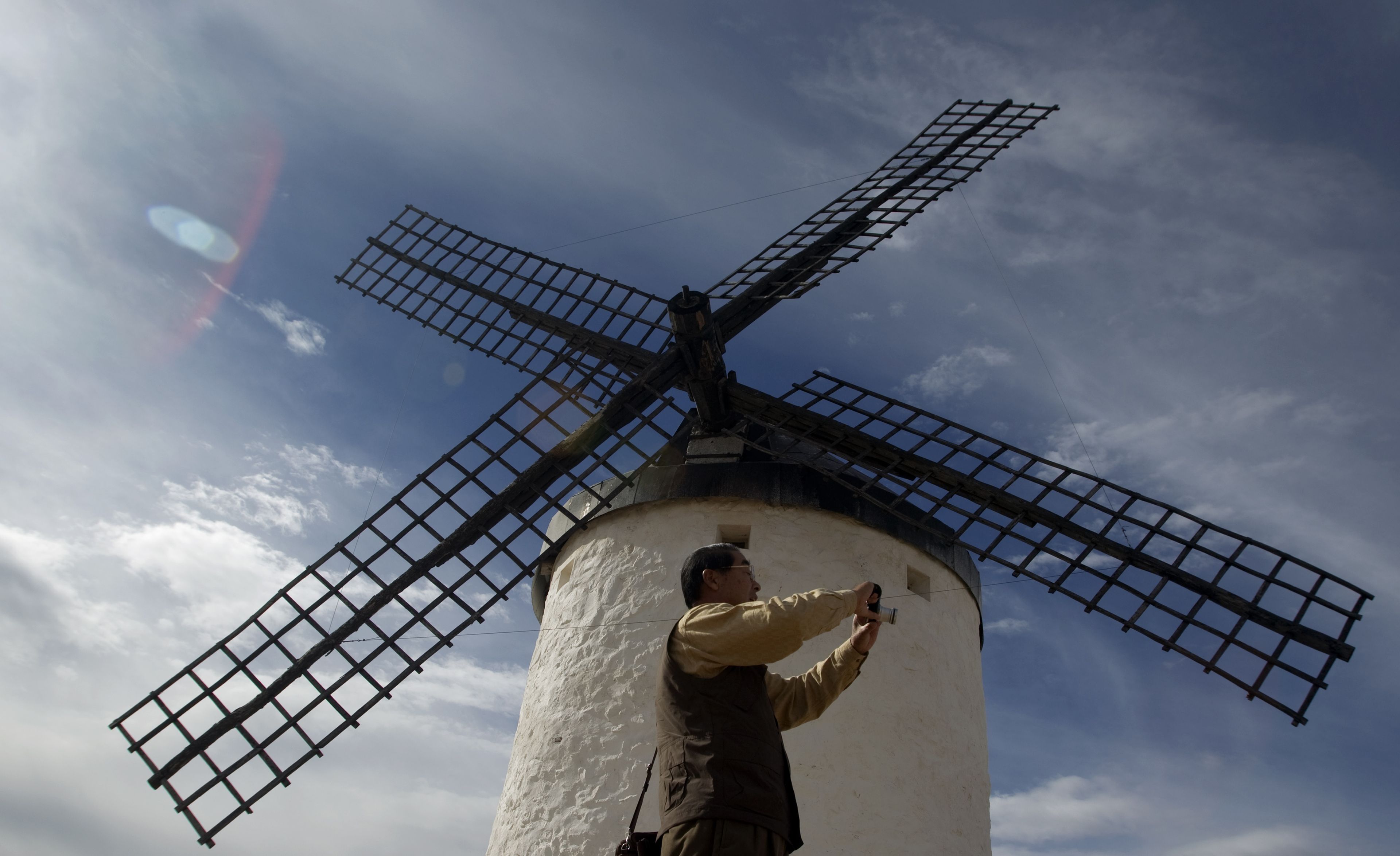 Un turista japonés se hace un selfie en un molino de viento en Consuegra (Toledo, Castilla-La Mancha)