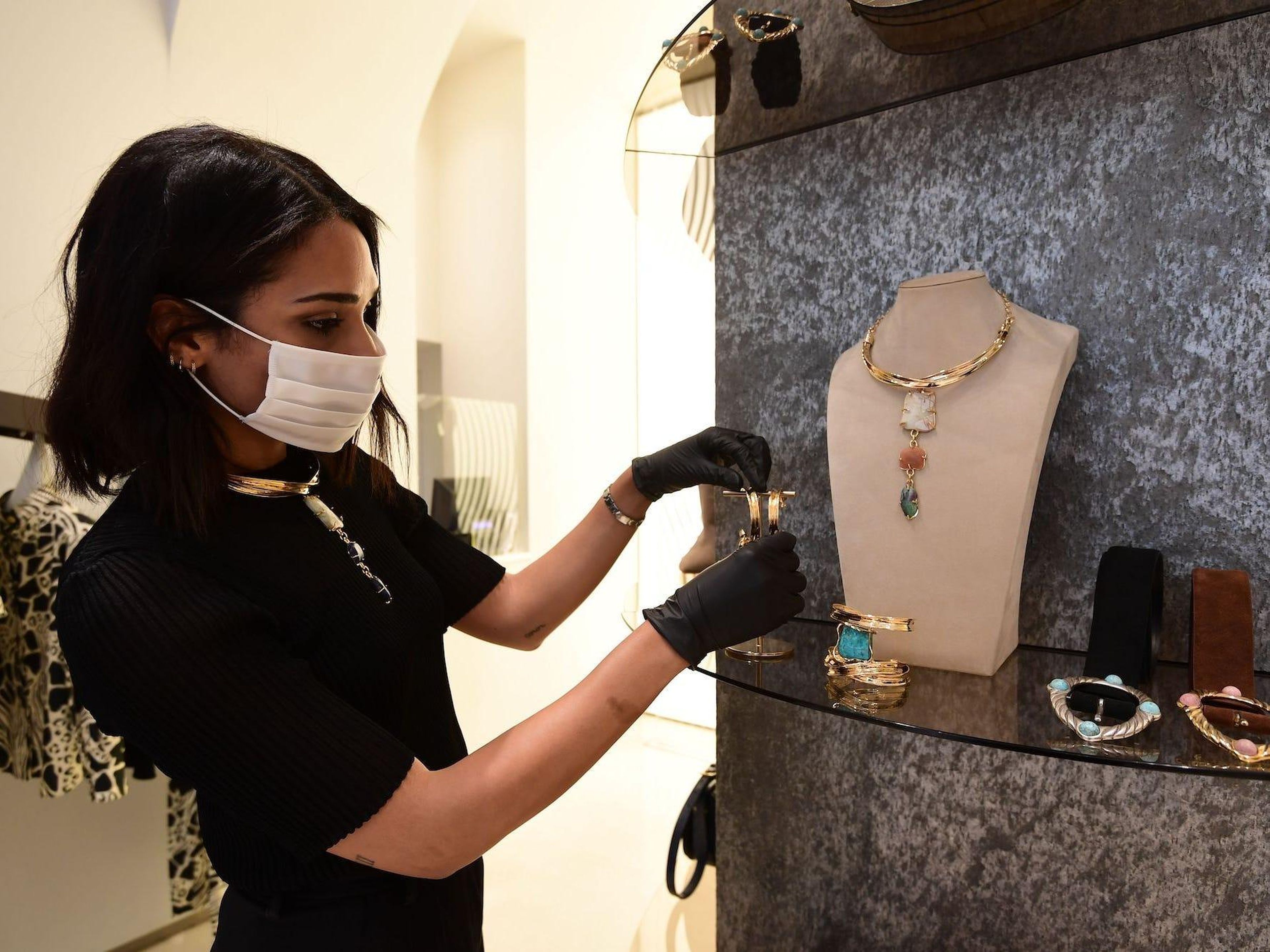 A woman arranging high-end jewelry at a shop in Milan, Italy. Miguel Medina/AFP via Getty Images