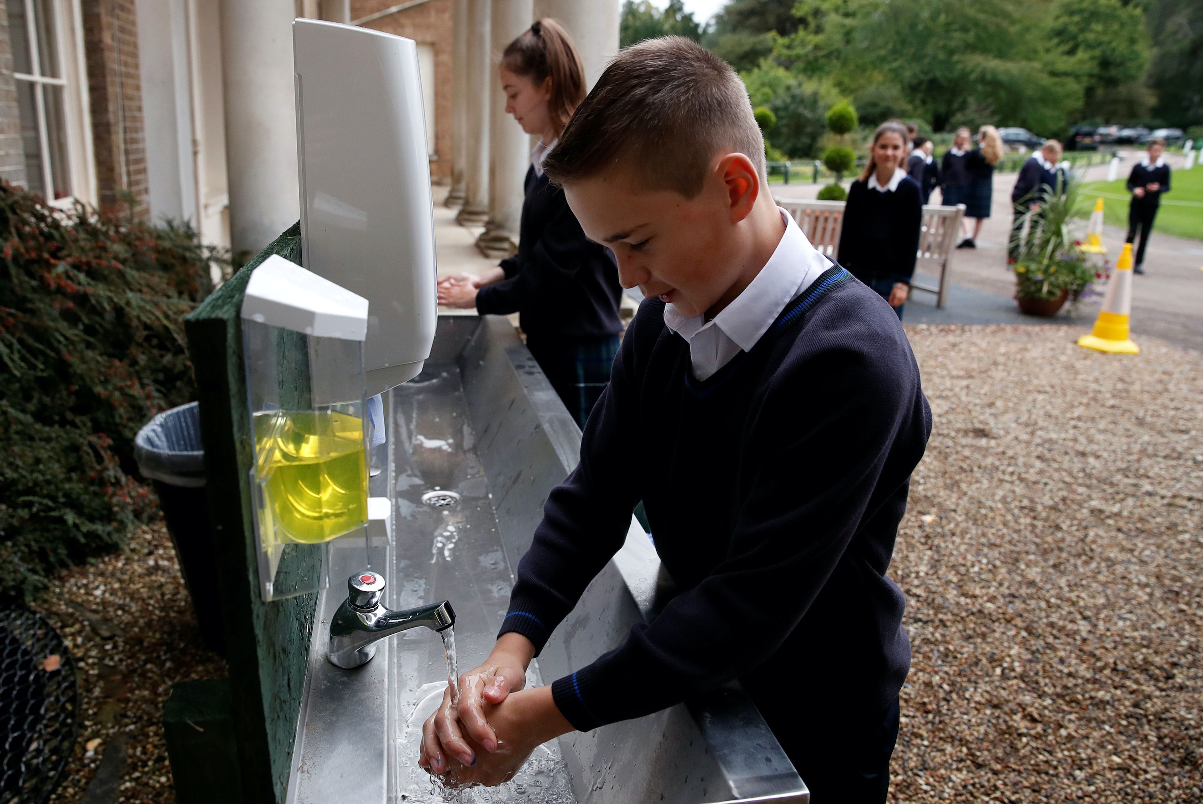 Alumno británico lavándose las manos