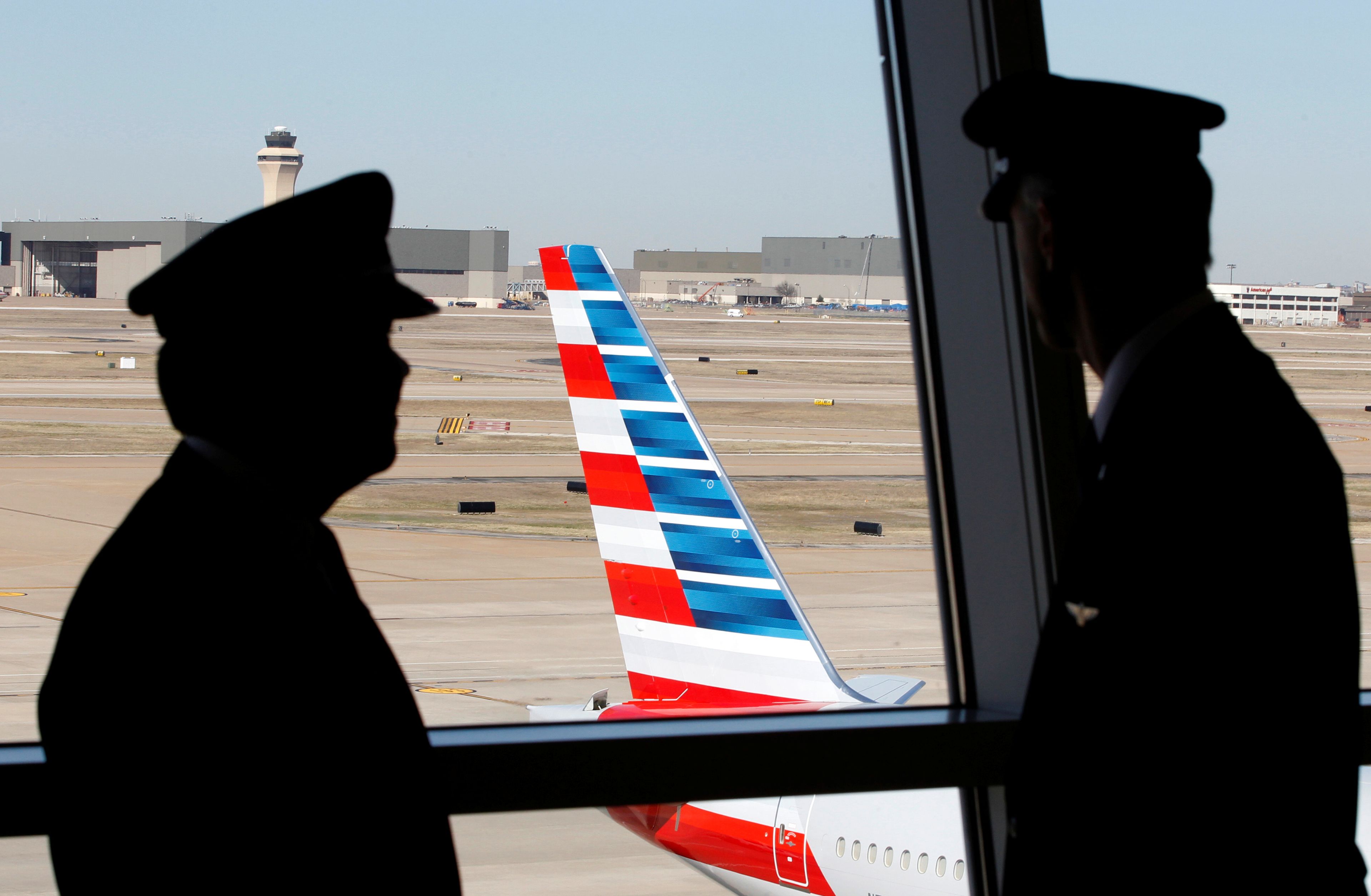 Pilotos hablan mientras observan un avión de American Airlines en el Aeropuerto Internacional de Dallas-Fort Worth, en Texas, EEUU.