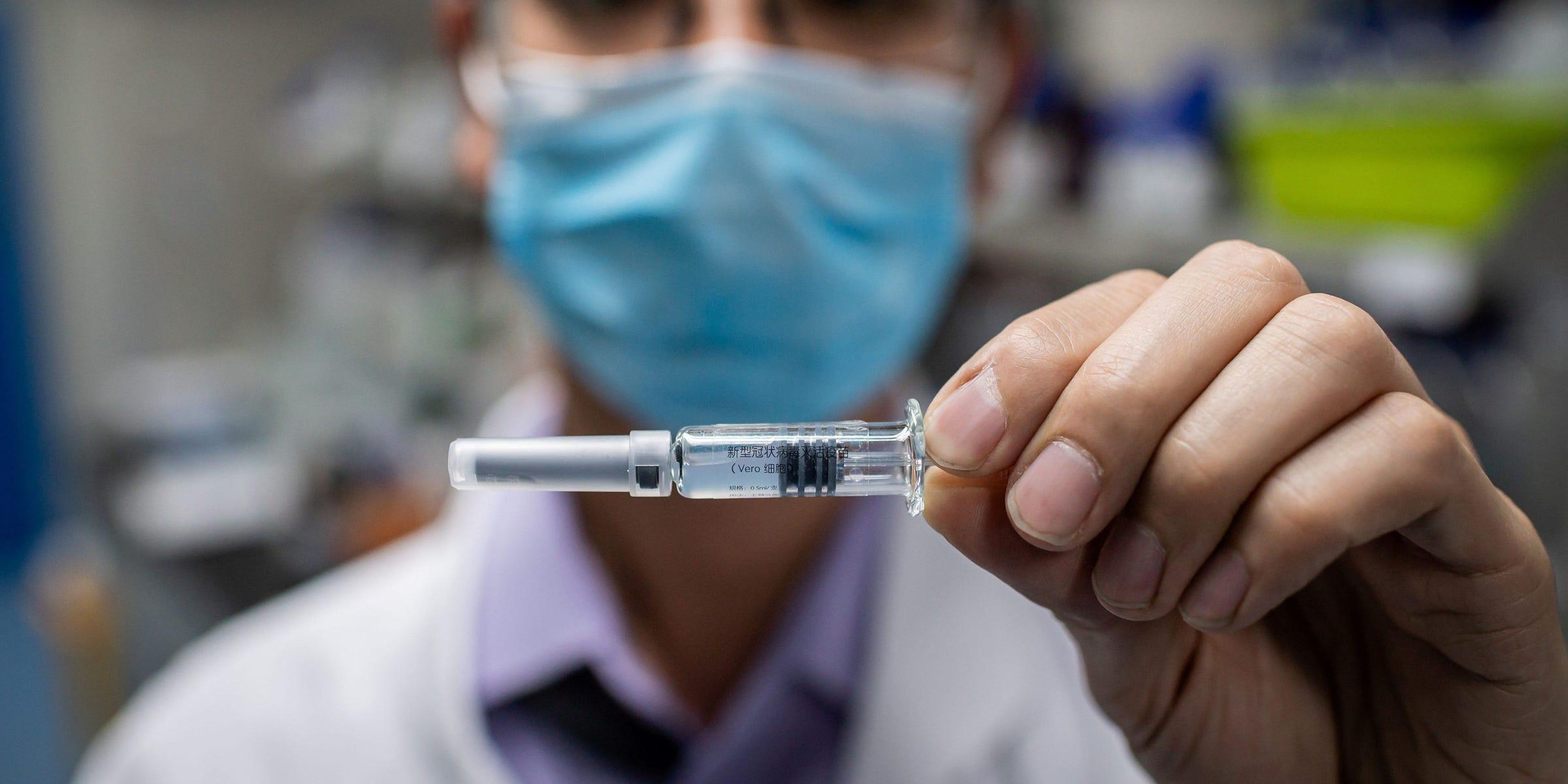 A researcher holds up a dose of a Chinese coronavirus vaccine candidate.