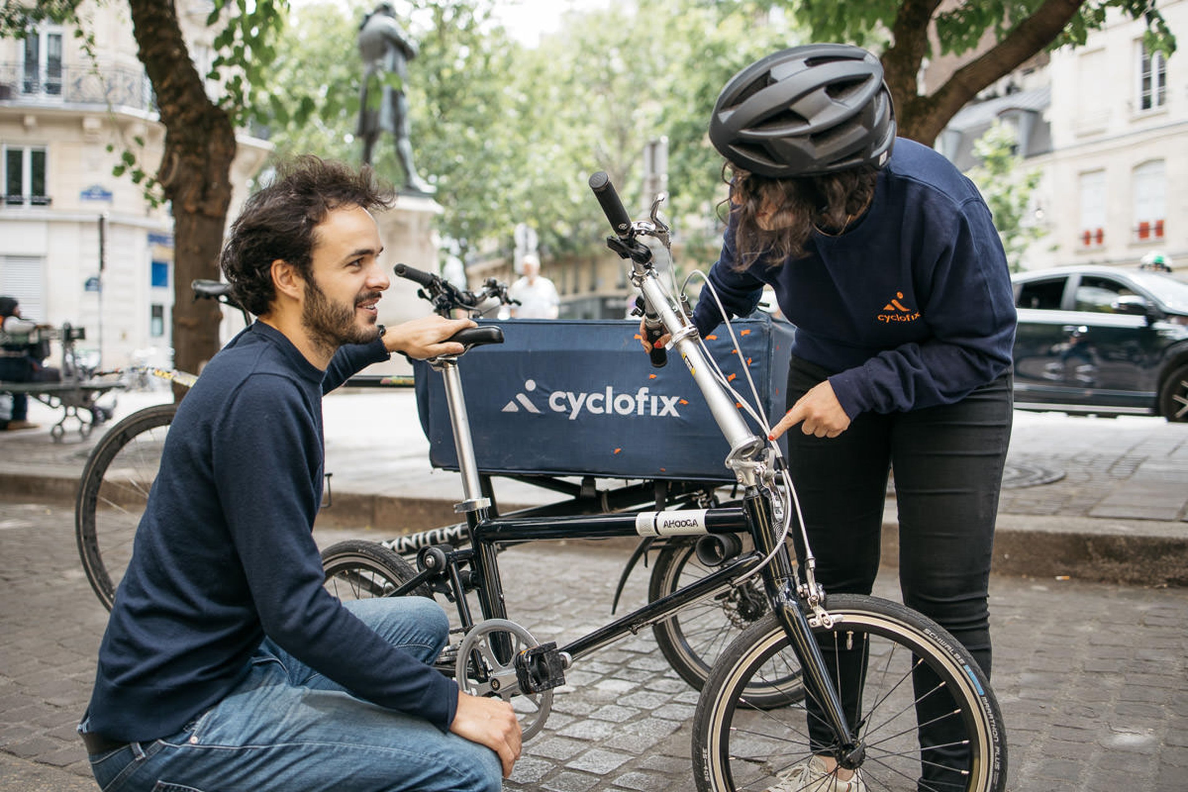 Una mecánica de la francesa Cyflofix arregla una bicicleta en plena calle.