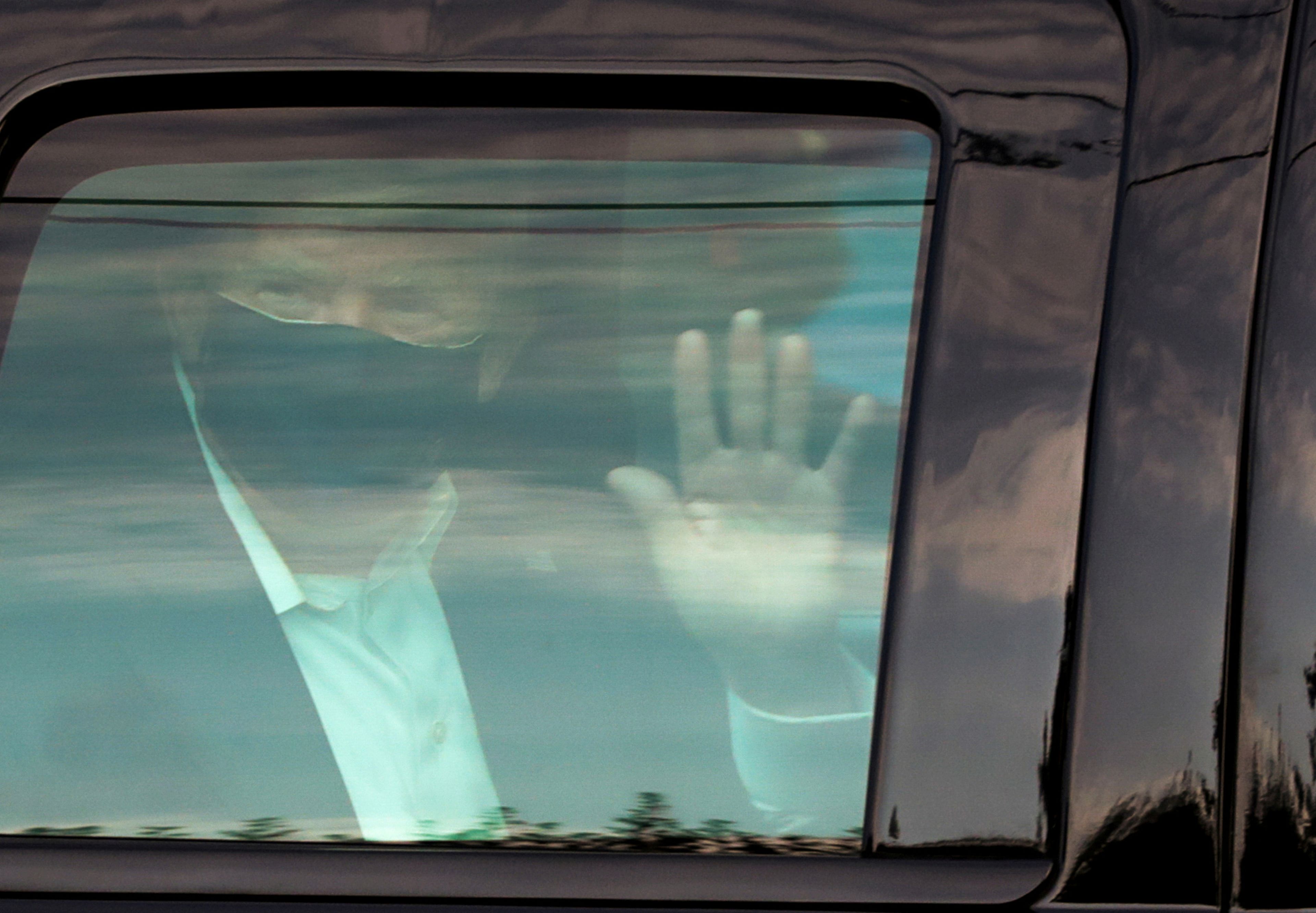 Donald Trump, presidente de Estados Unidos, saluda tras salir a dar un paseo dentro del coche en medio de su cuarentena por coronavirus.