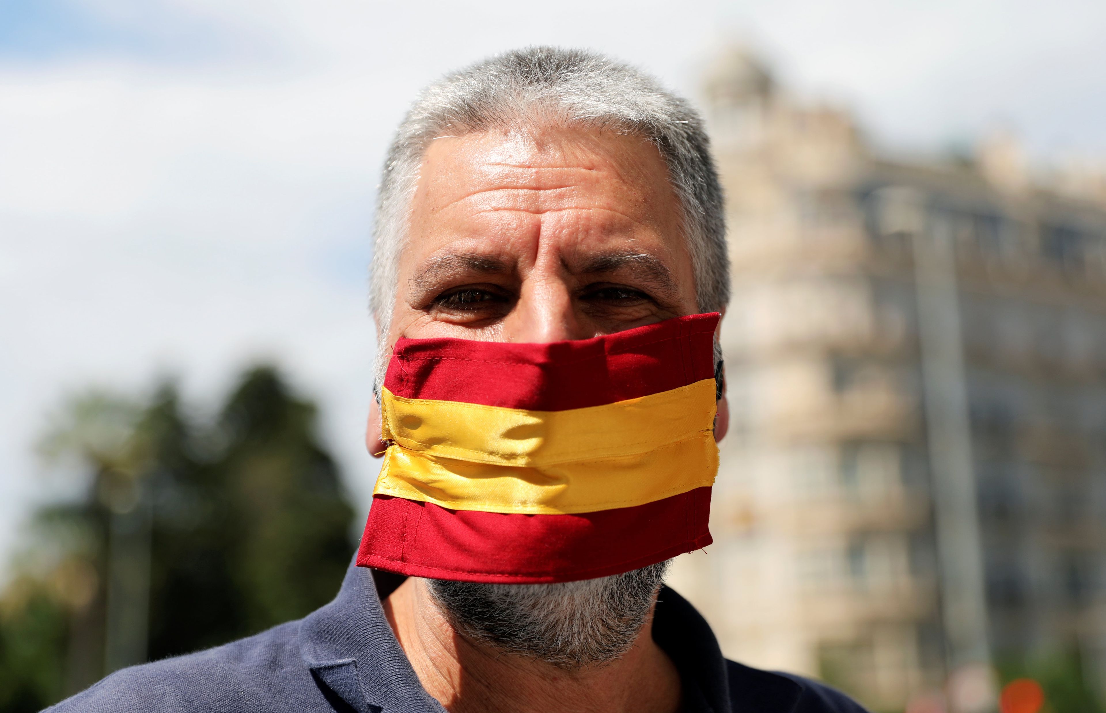 Un hombre con una mascarilla con la bandera de España.