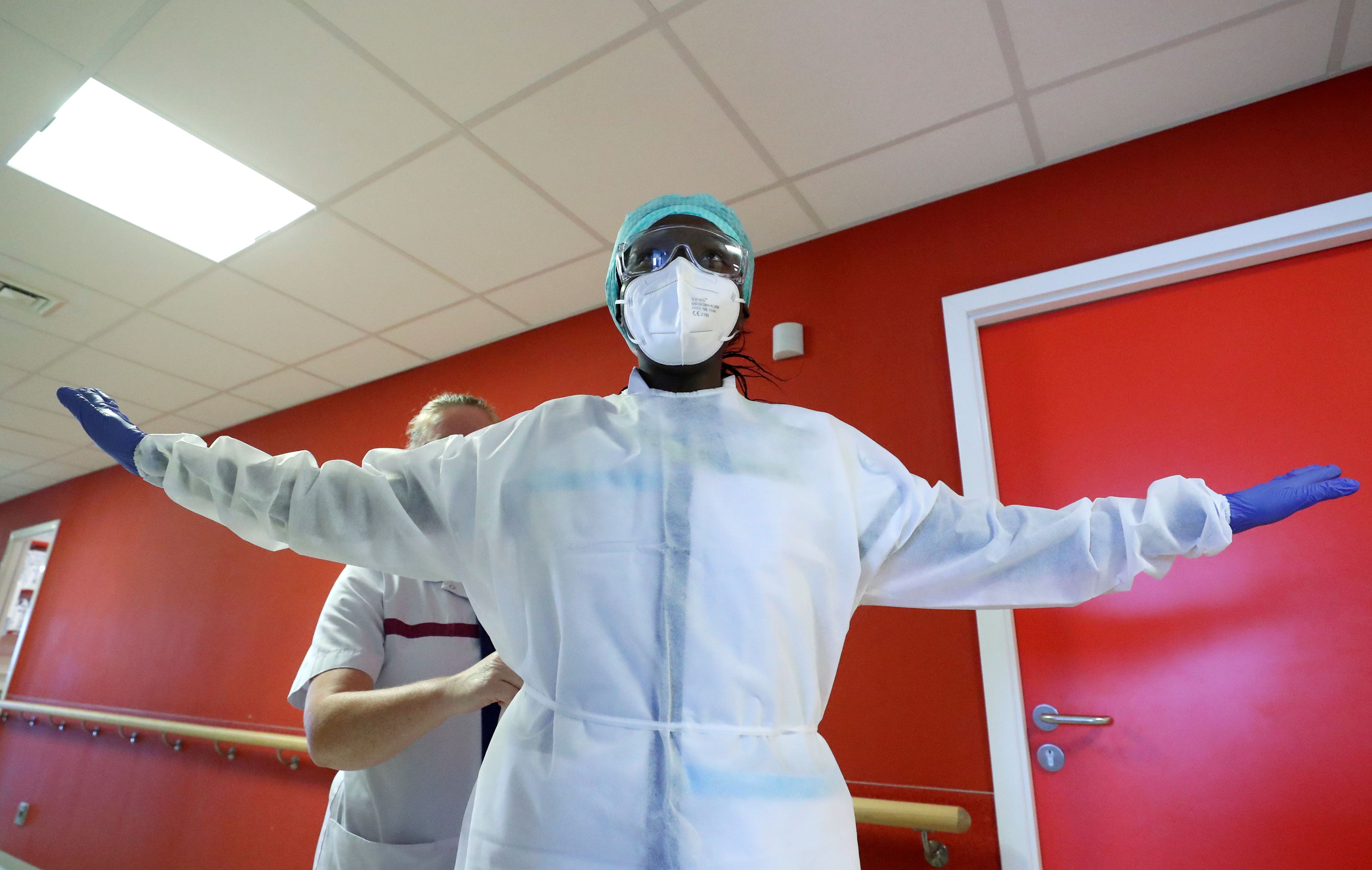 Un médico se viste en el hospital durante la pandemia del coronavirus
