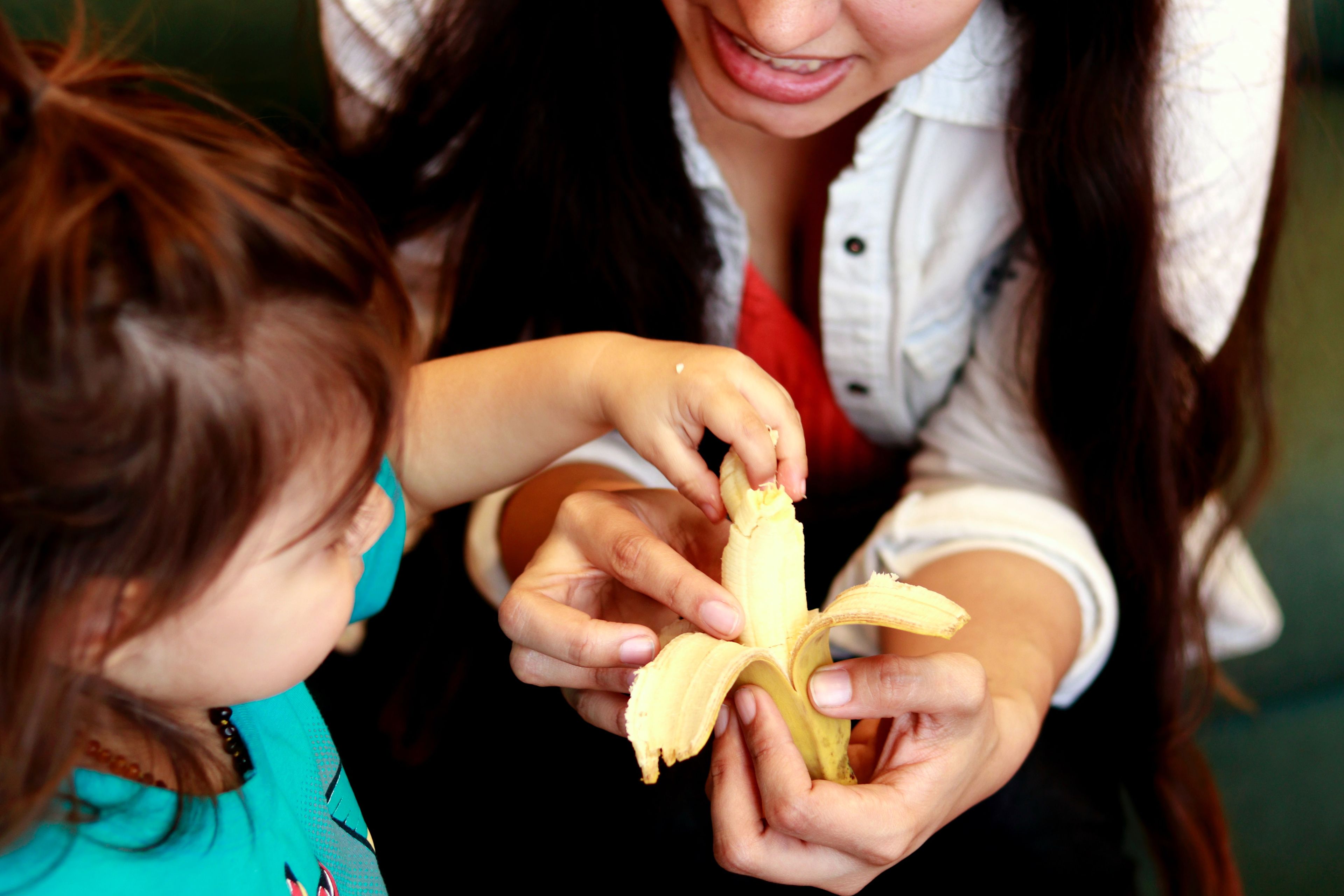 mujer dando fruta a un niño, plátano.