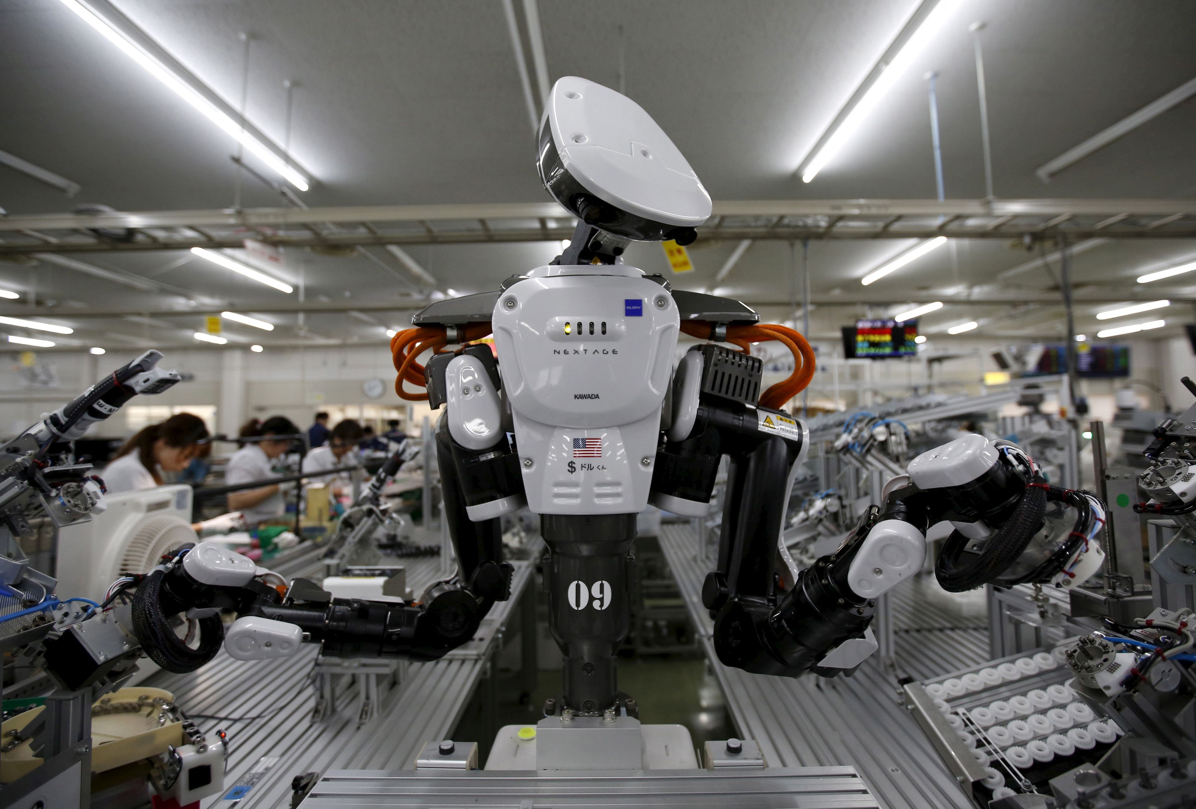 Un robot trabaja junto a empleados de la empresa Glory Ltd en Kazo, al norte de Tokio, en Japón.