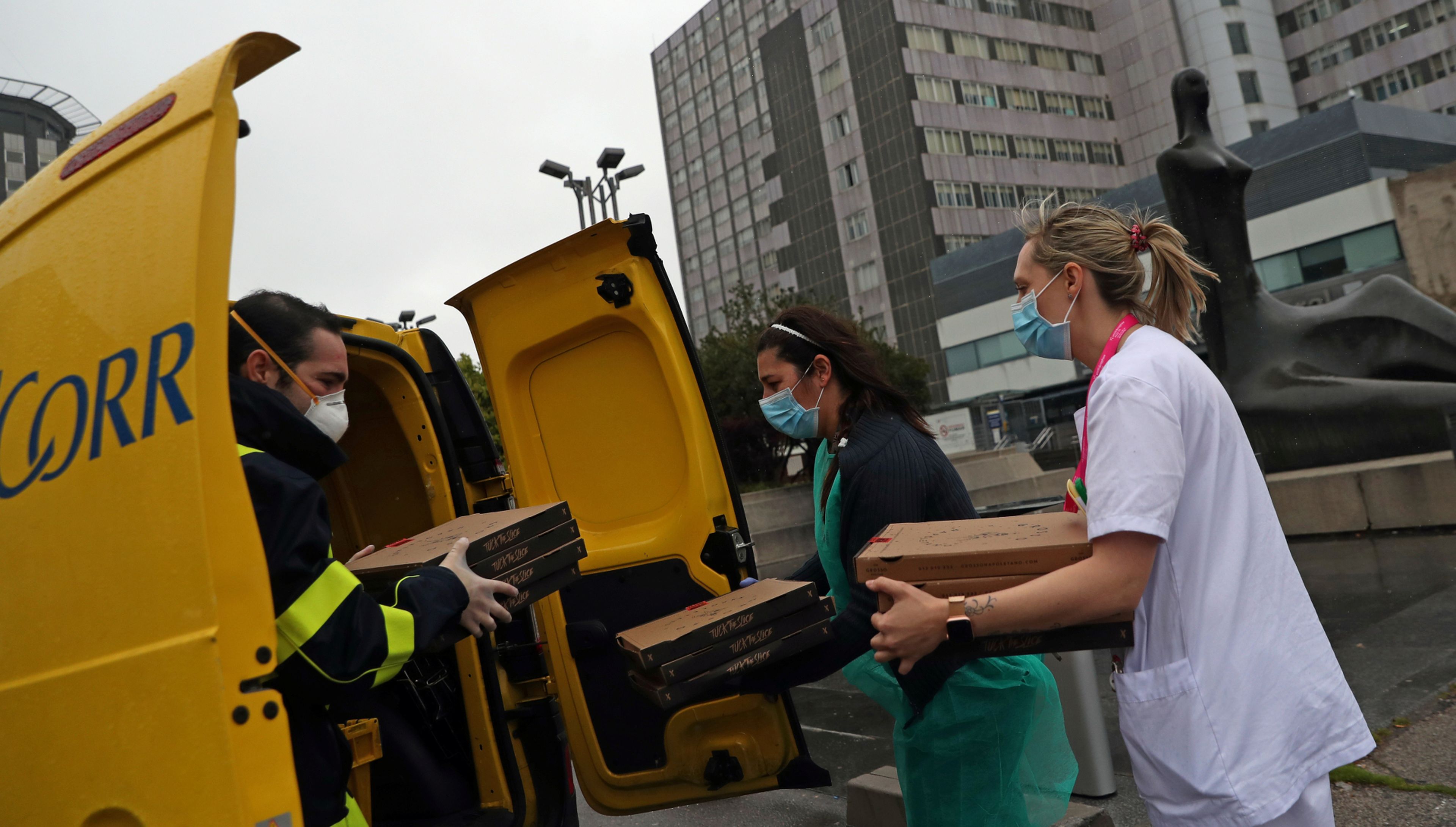 Un trabajador de Correos entrega comida a domiciio a trabajadores del hospital madrileño de La Paz