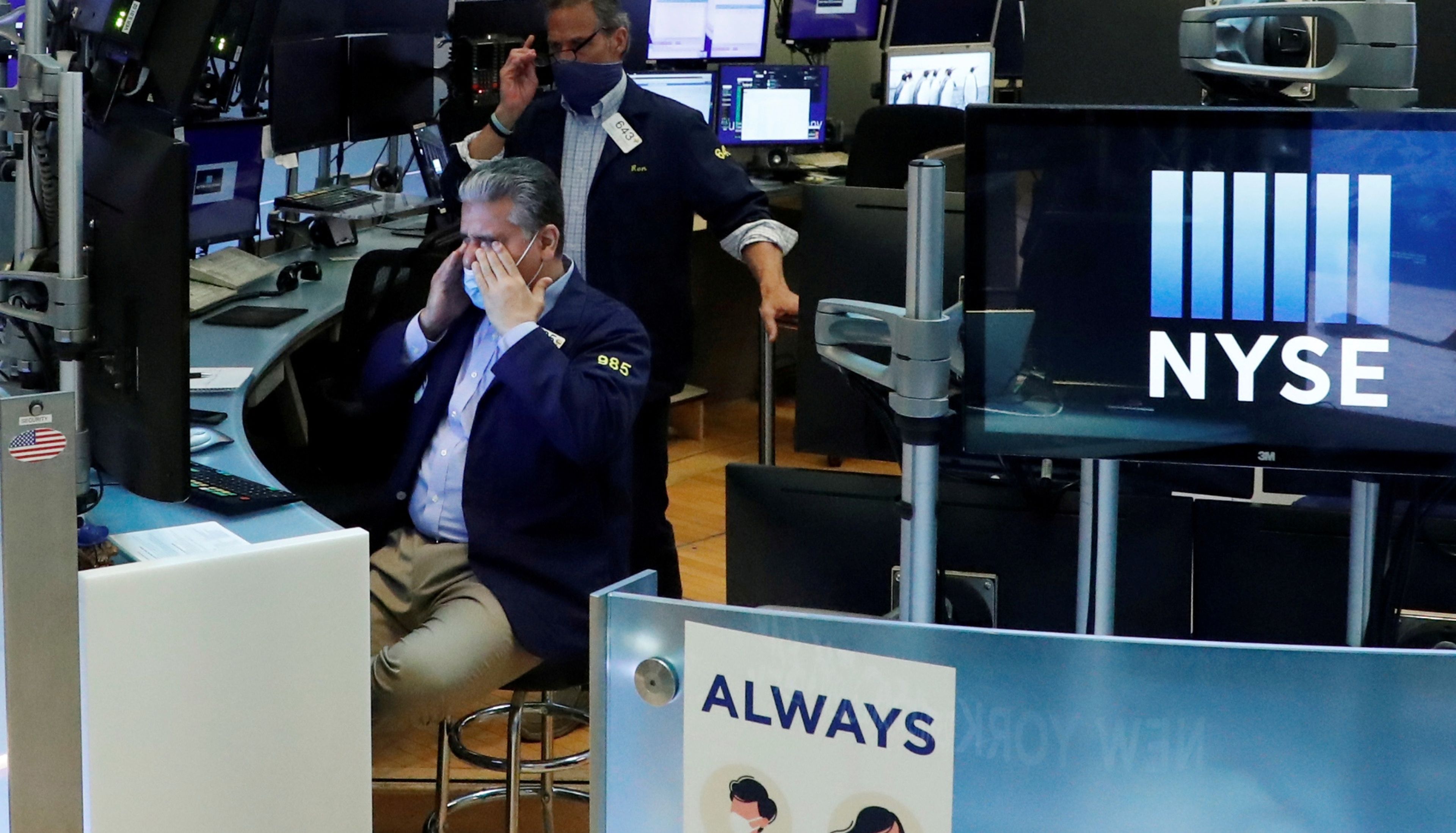 Un trader de Wall Street con mascarilla se muestra preocupado ante la evolución de la Bolsa de Nueva York