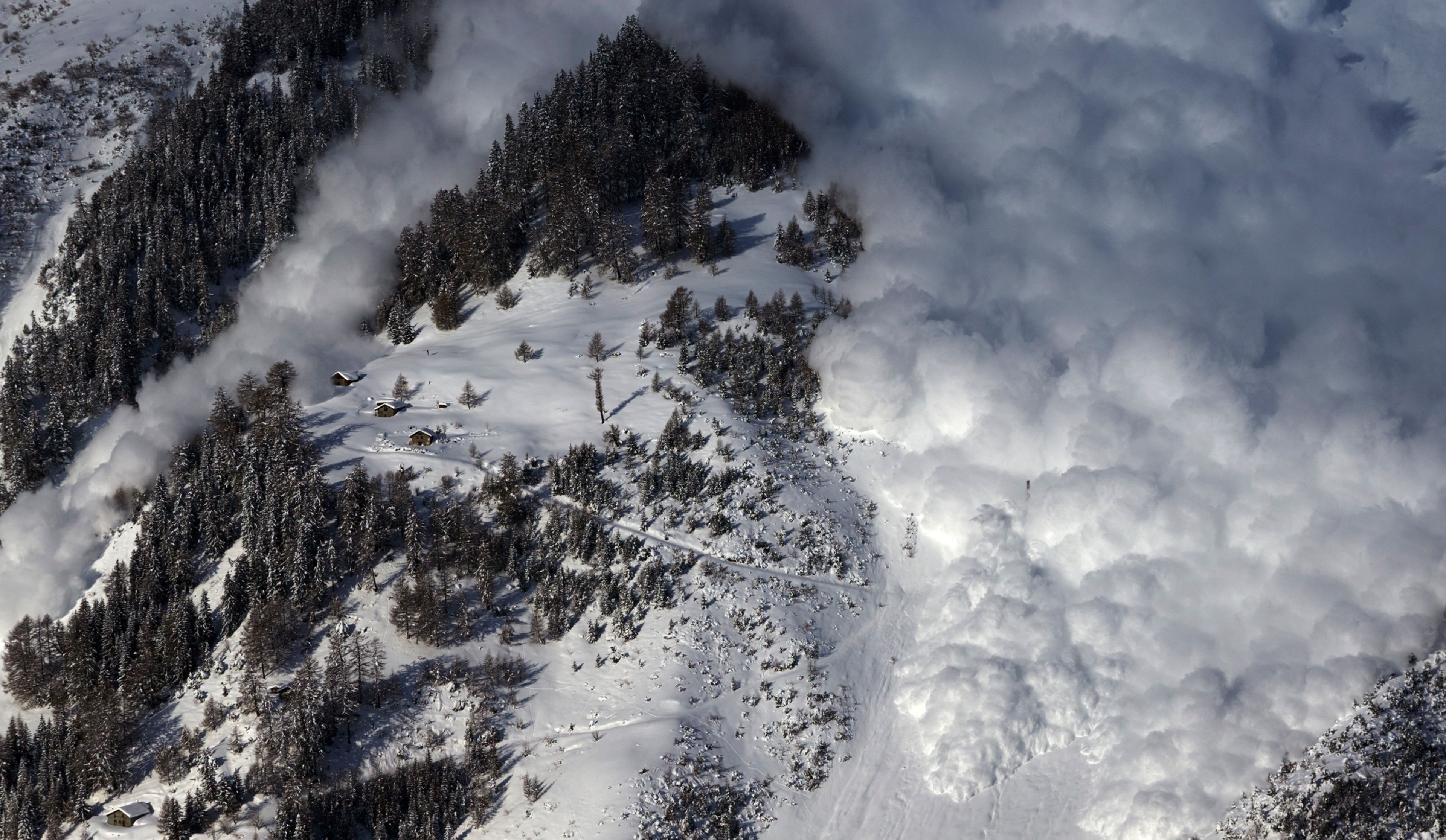 Una avalancha de nieve cae sobre una montaña en los Alpes suizos