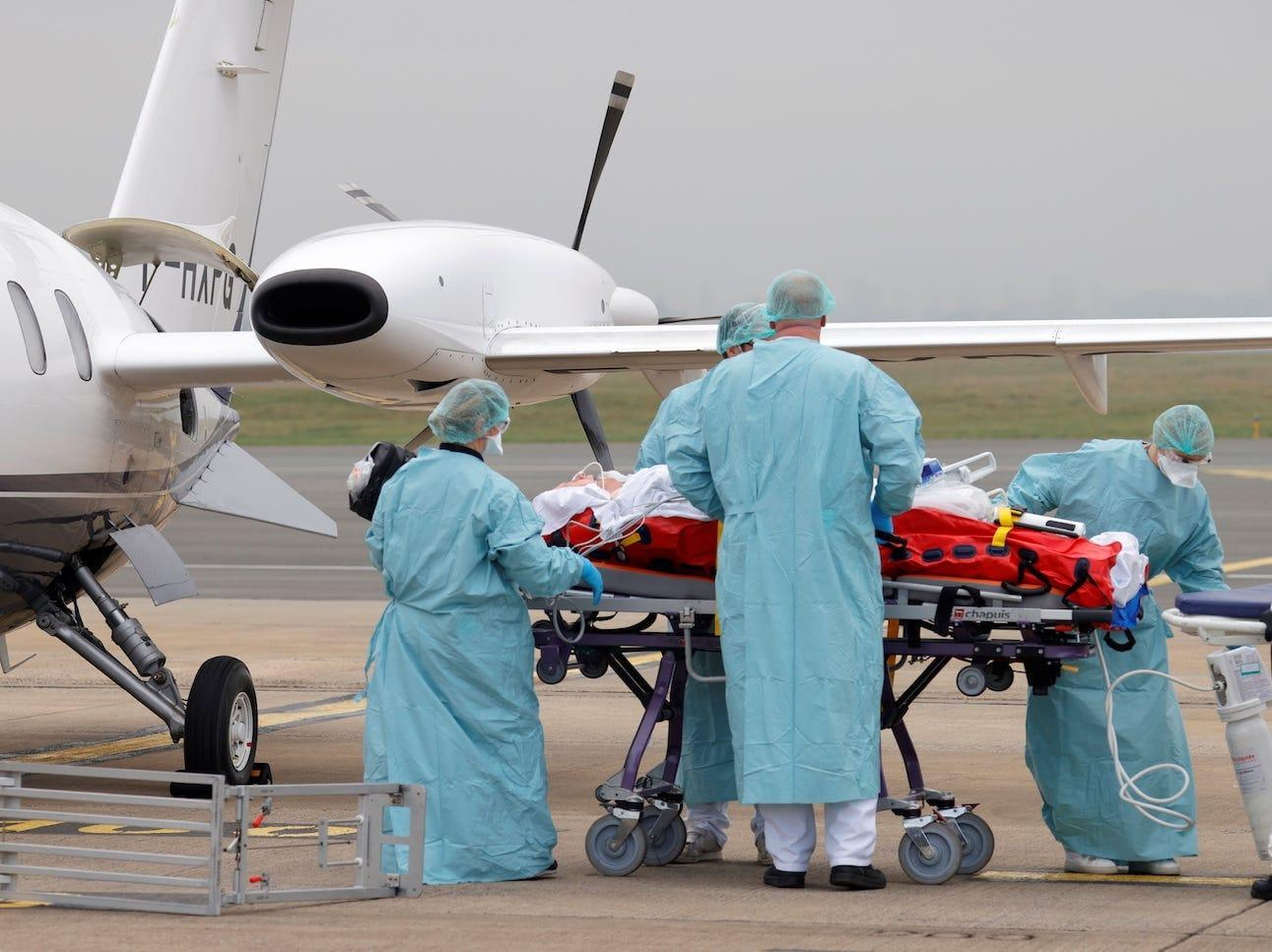 Miembros del personal médico trasladan a un paciente que padece el coronavirus a un avión durante una operación de traslado desde el aeropuerto de Lille-Lesquin, en Francia, al aeropuerto de Munster, en Alemania, el 10 de noviembre de 2020.