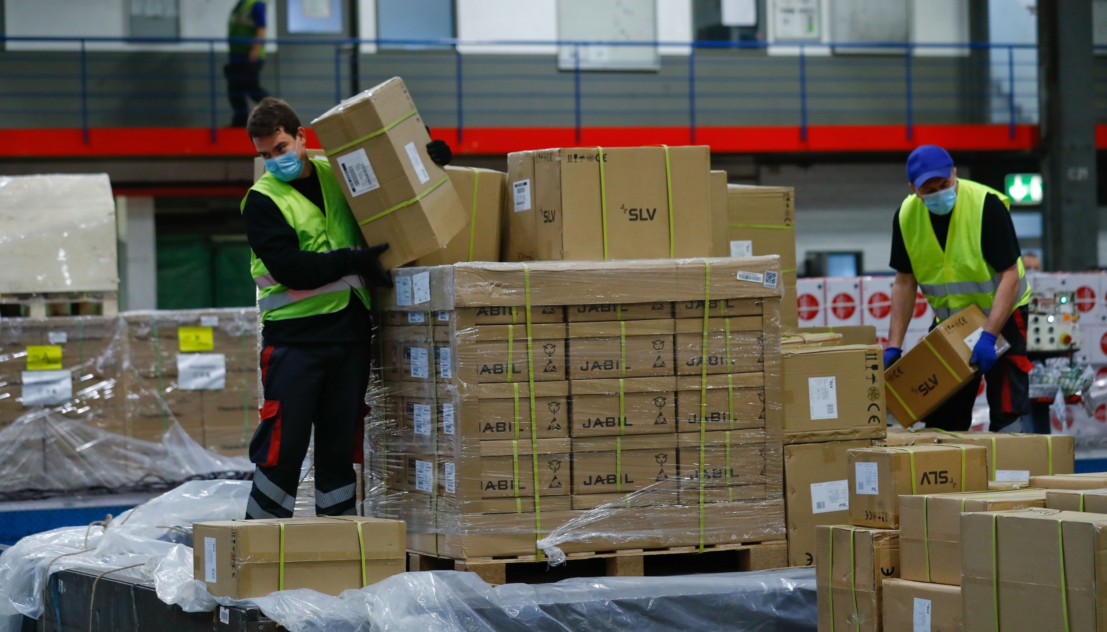 Dos operarios desembalan un palé de paquetes en el aeropuerto de Frankfurt