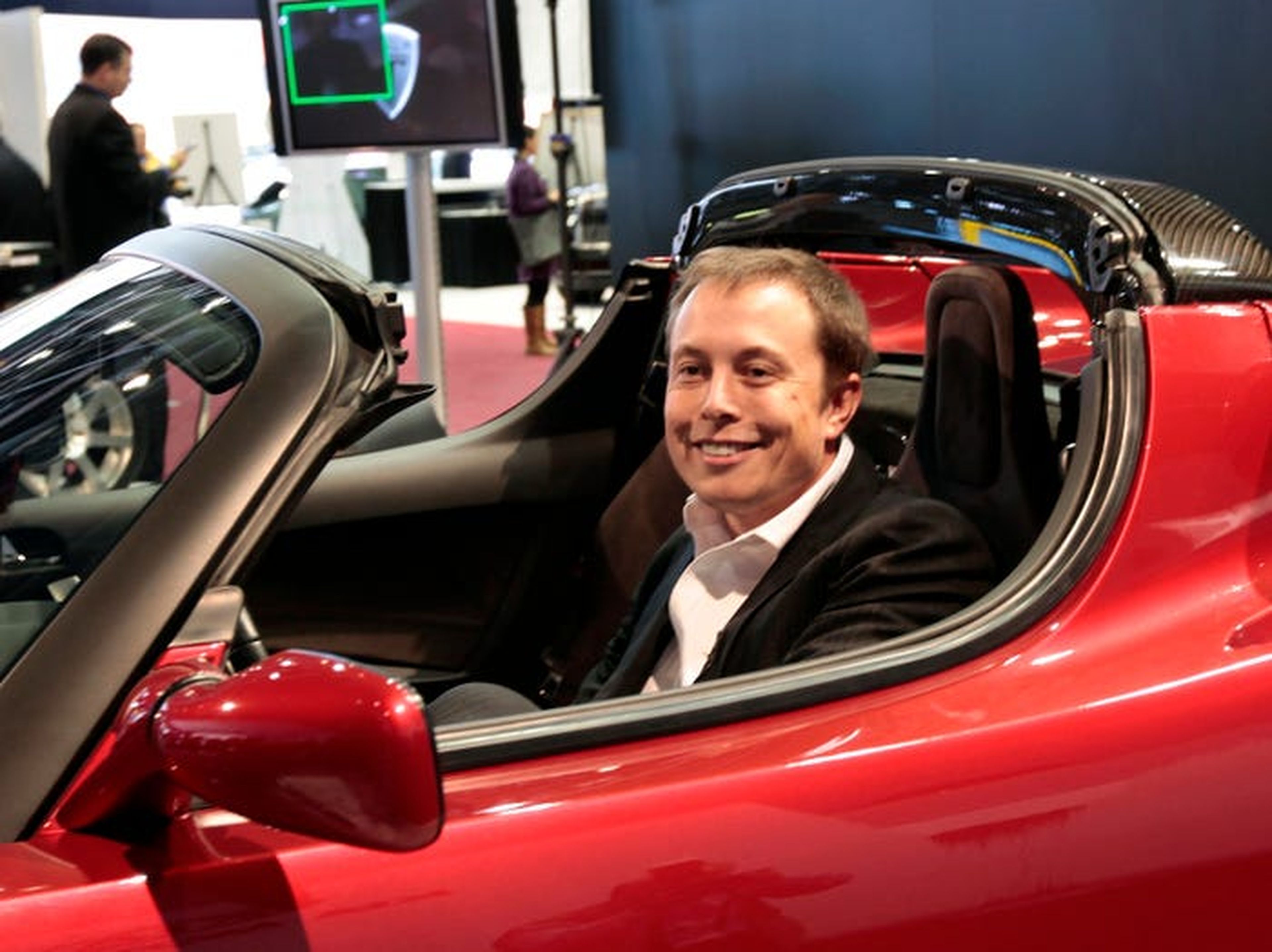 Elon Musk en un coche rojo