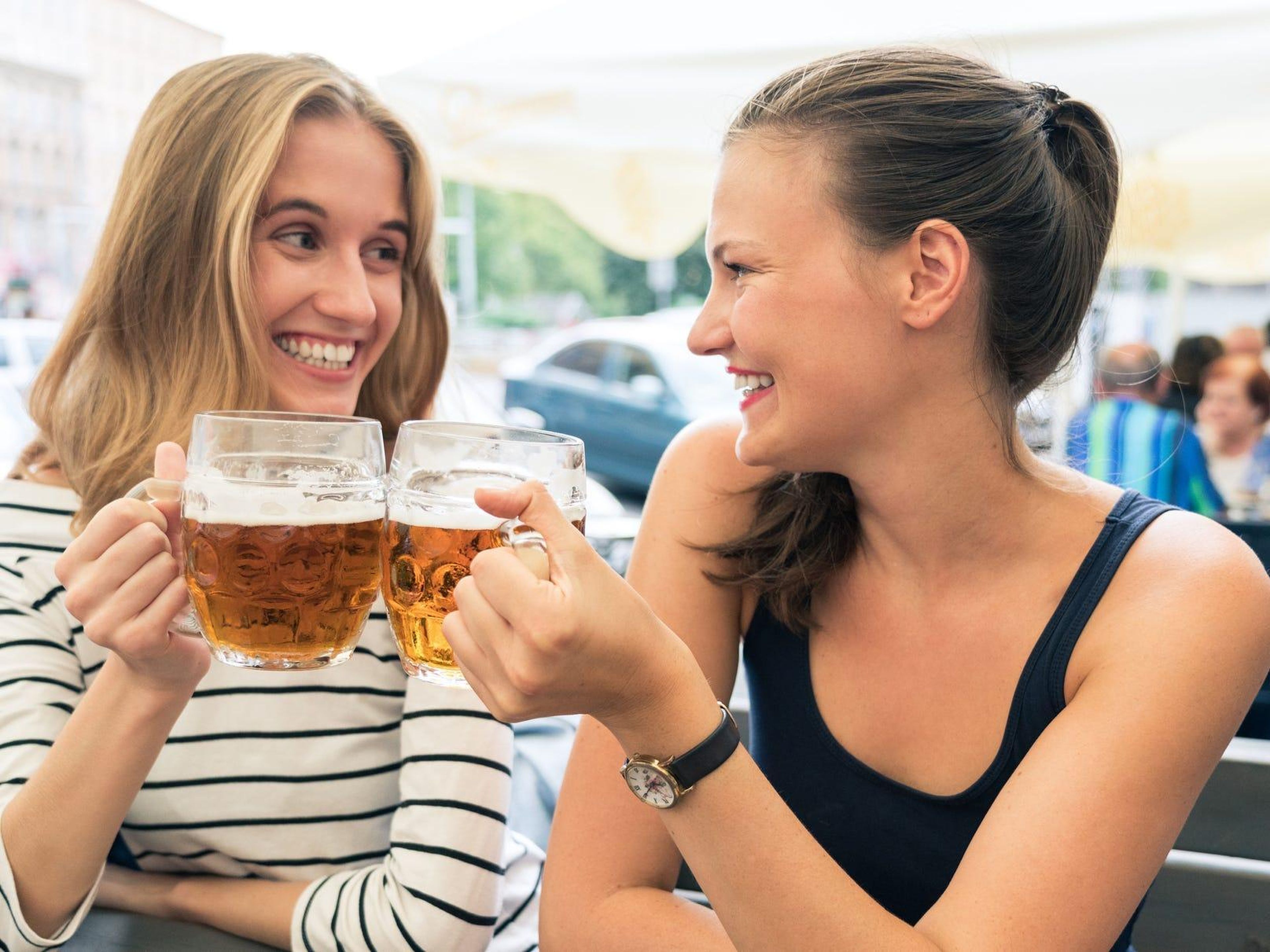 Dos chicas tomándose una cerveza en una terraza.