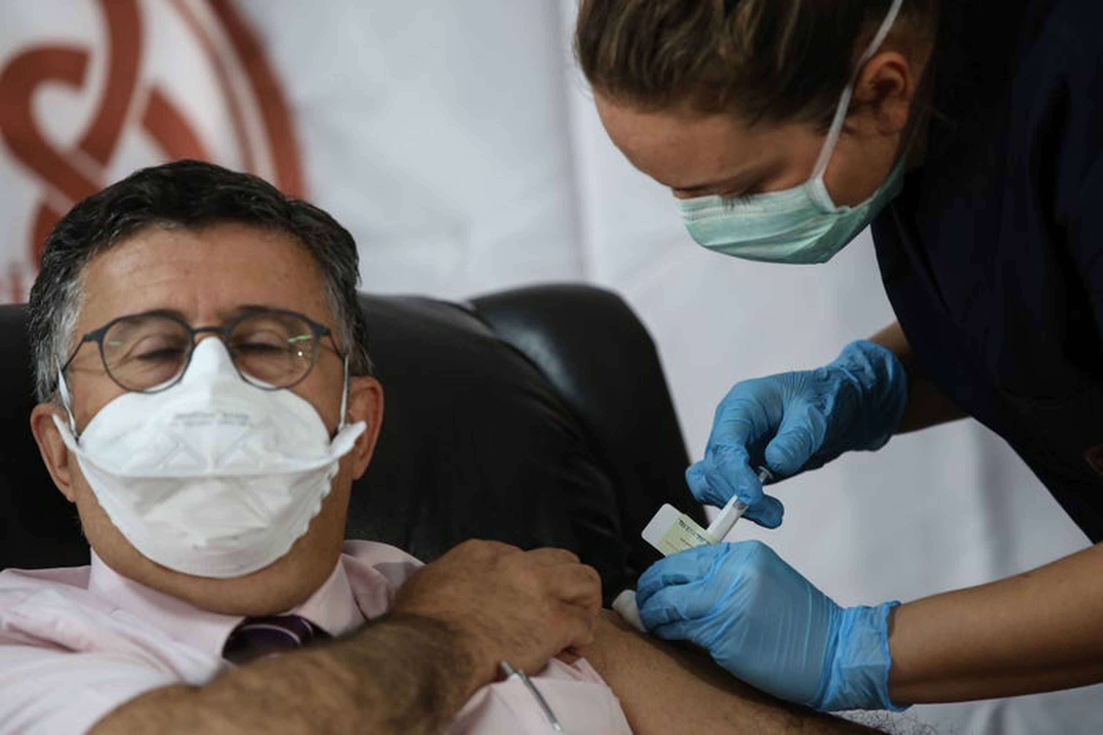A healthcare worker in Turkey injects a patient with the vaccine candidate from Pfizer and BioNTech in a phase 3 trial in October 2020.