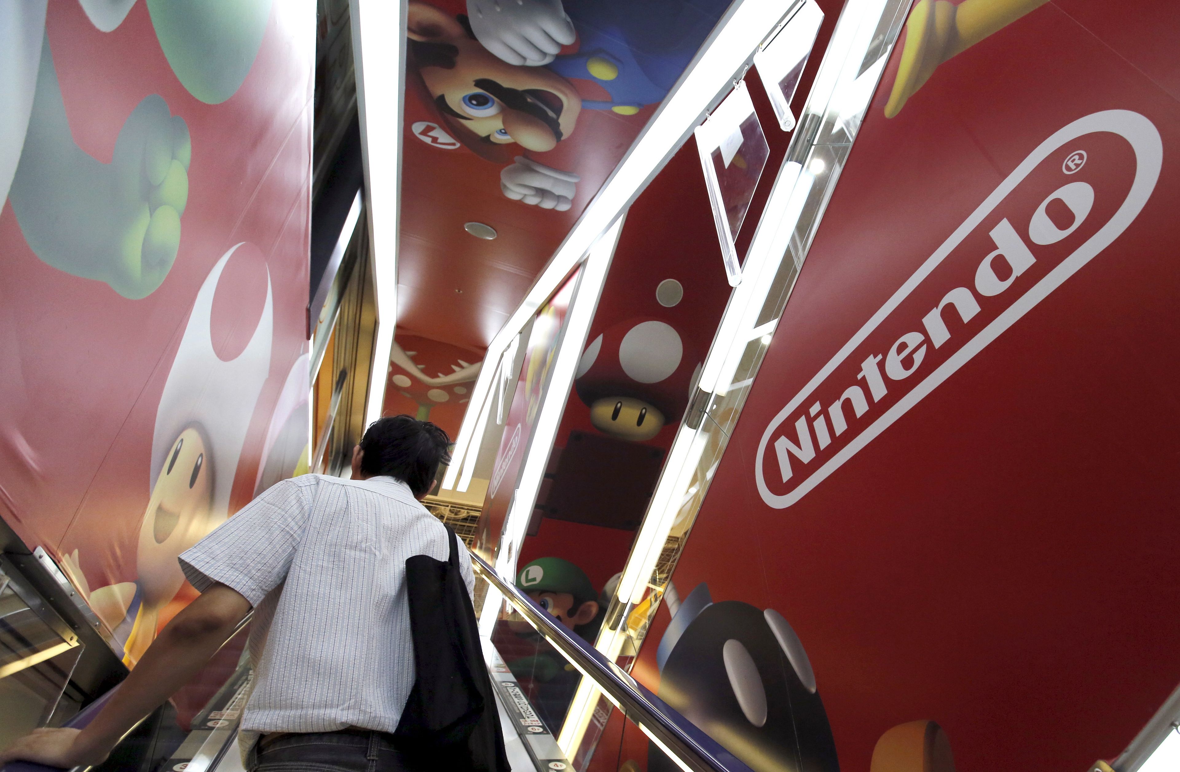 Un hombre subiendo por unas escaleras mecanicas decoradas con motivos de Nintendo