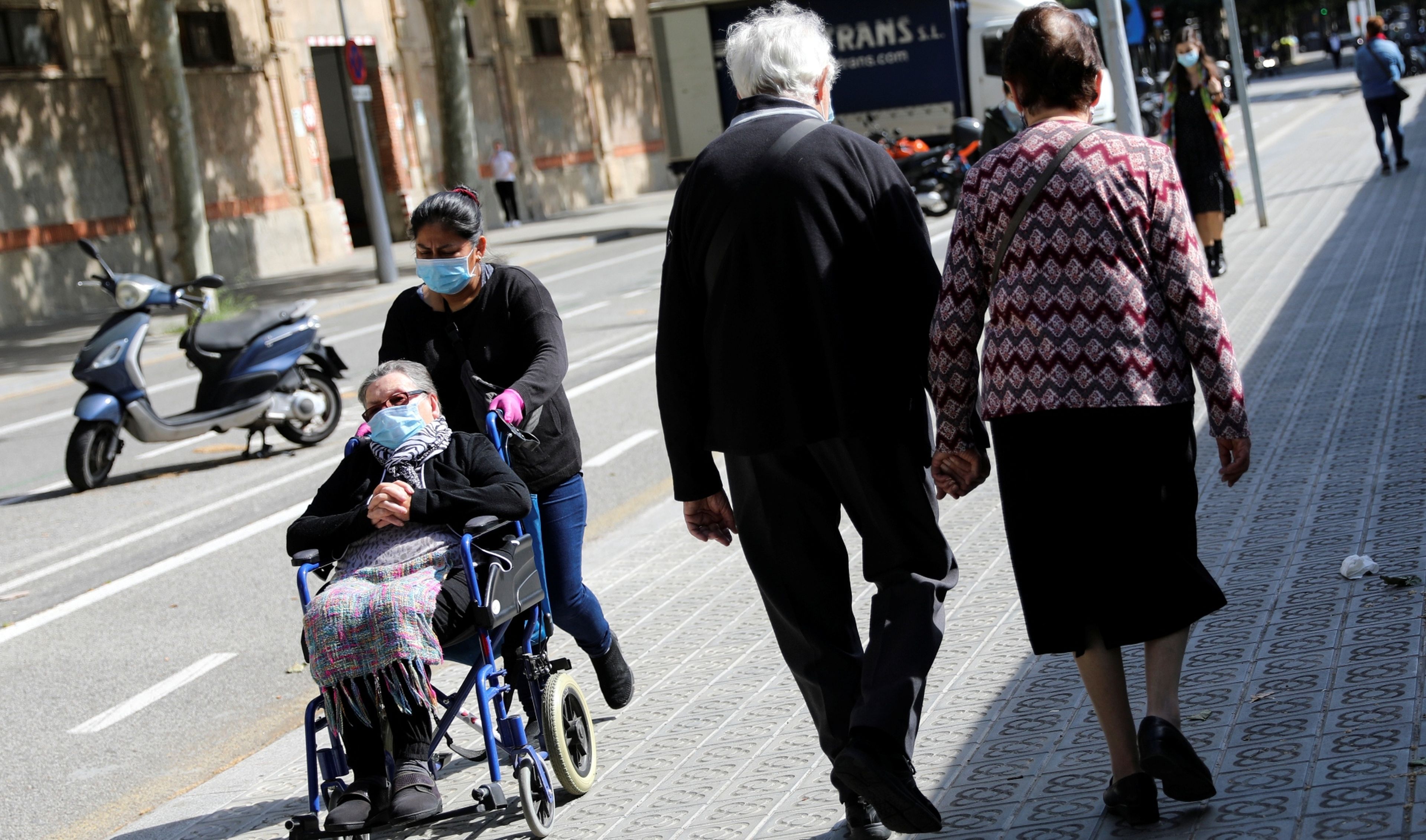 Jubilados pasean con mascarilla por el centro de Barcelona