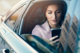 Mujer en el coche mirando el iPhone
