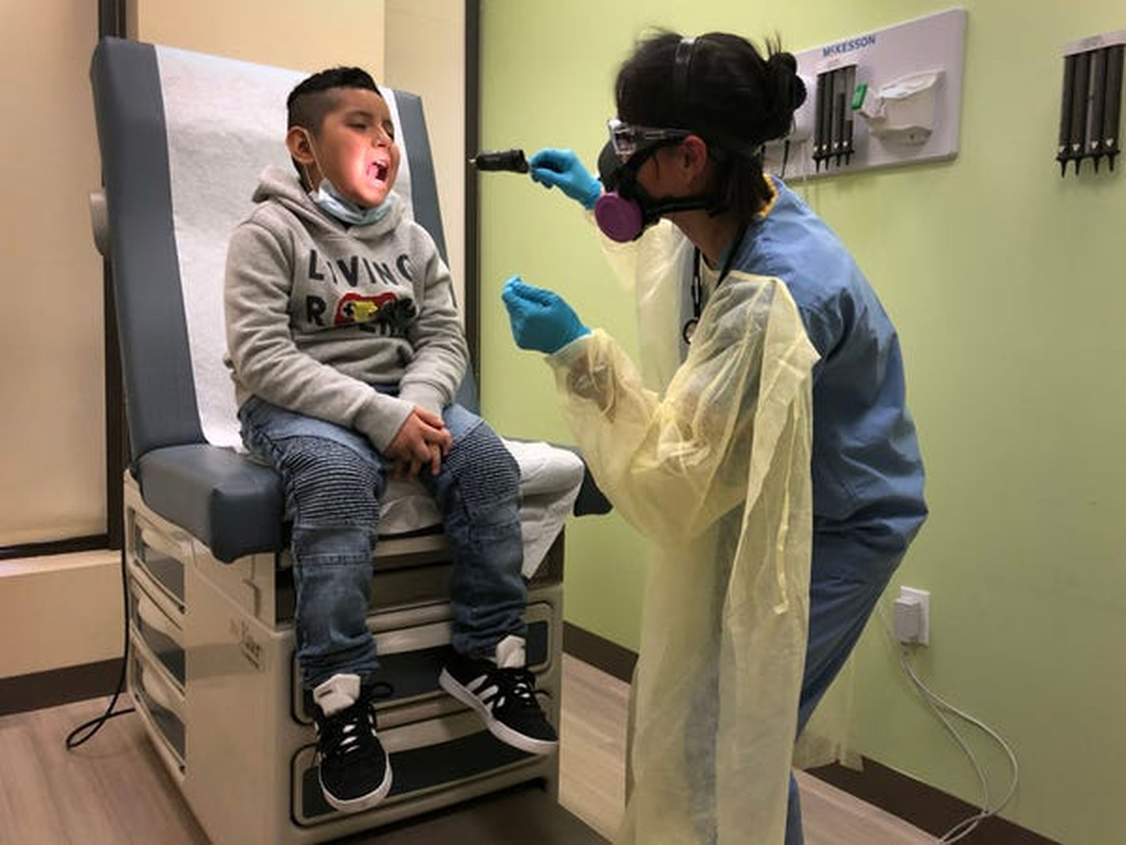 Un niño es examinado por un asistente médico antes de recibir una prueba de hisopo COVID-19 el 5 de mayo en Stamford, Connecticut.