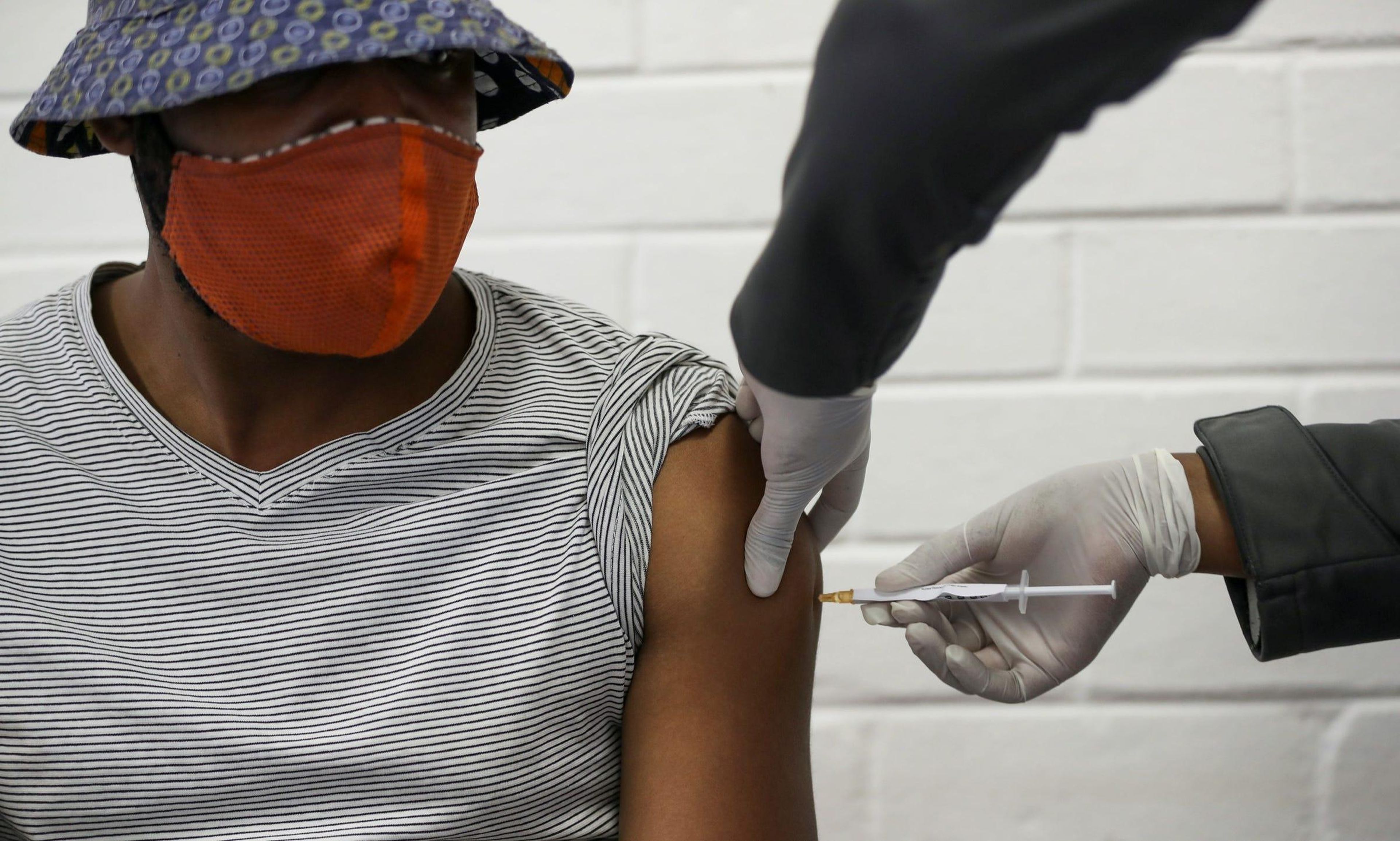 A volunteer receives an experimental coronavirus shot from a medical worker at Baragwanath Hospital in Soweto, South Africa, June 24, 2020.