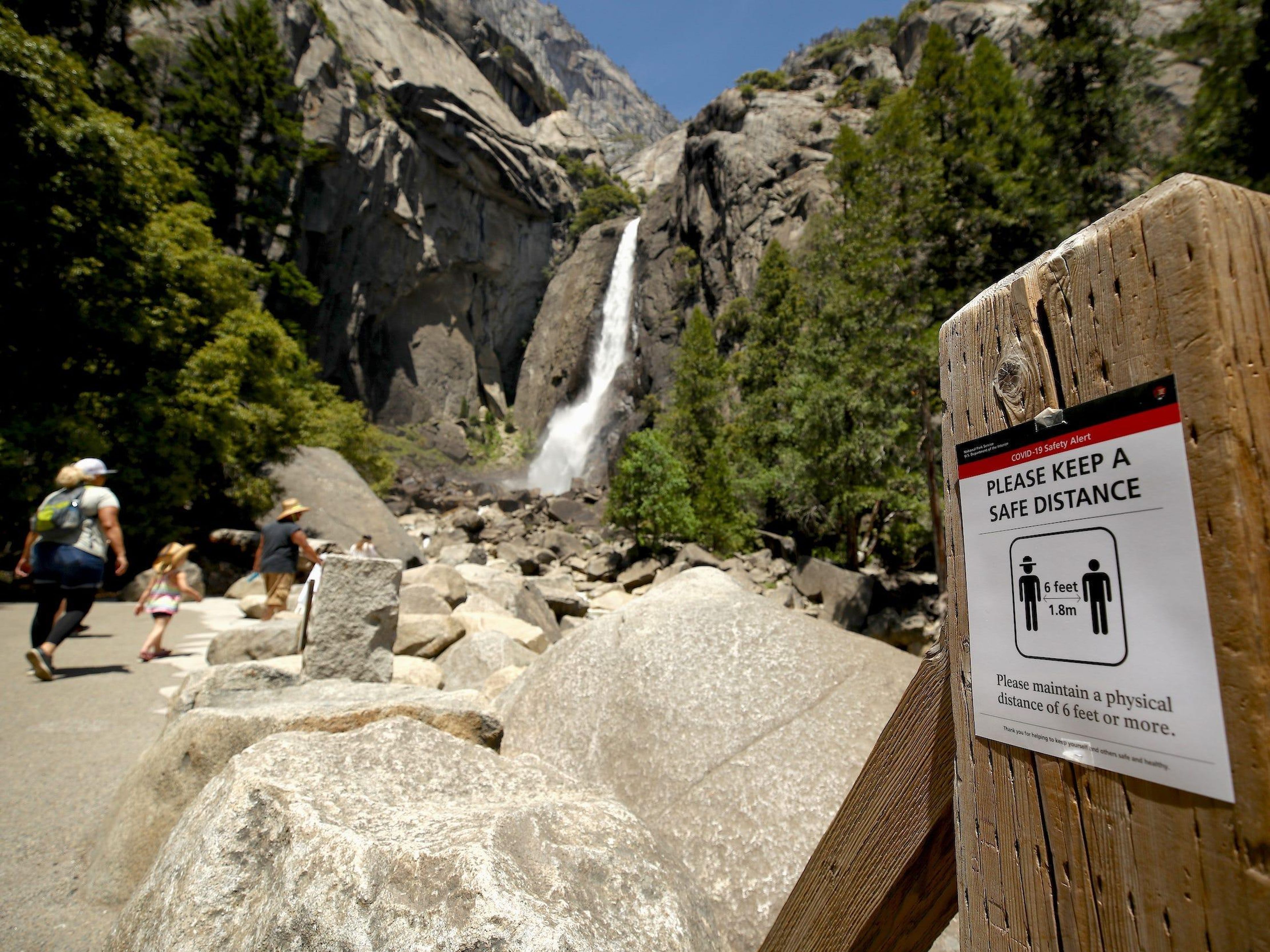 Un cartel que explica el distanciamiento social en las cataratas de Yosemite el 11 de junio de 2020, en el Parque Nacional de Yosemite, California, Estados Unidos.