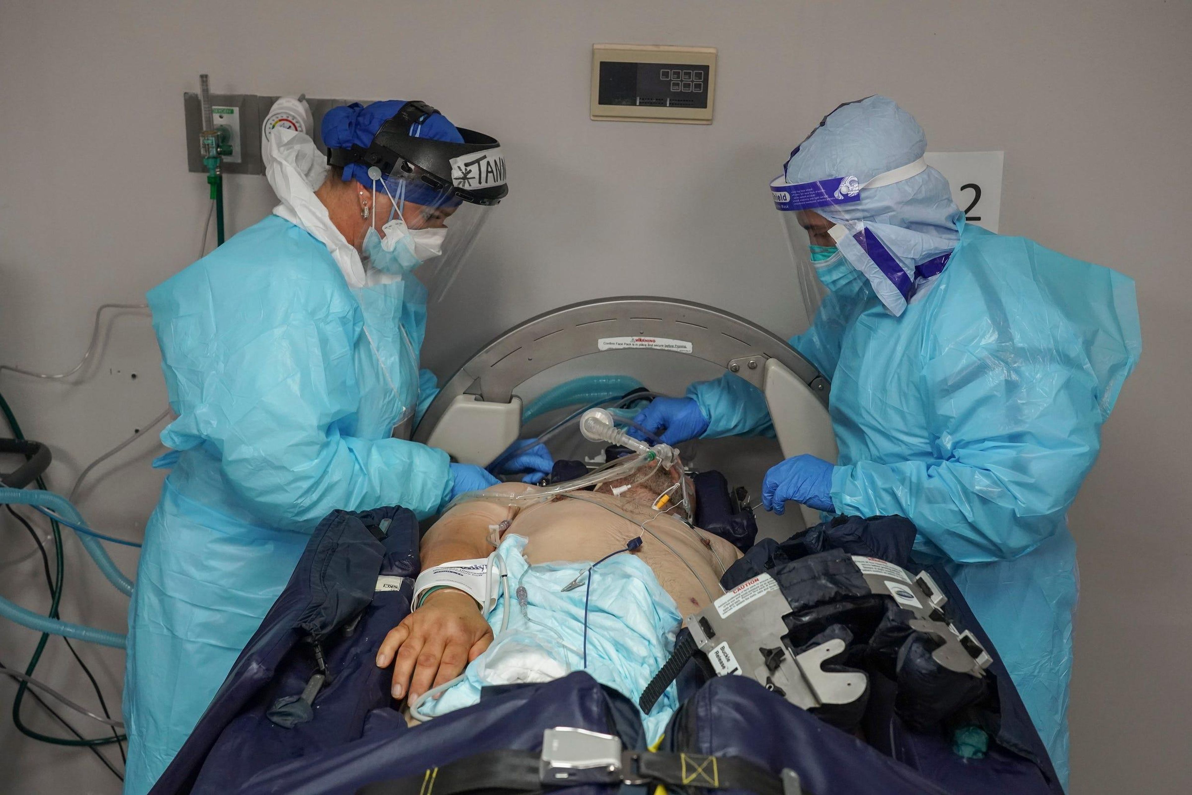 Los miembros del personal médico Tanna Ingraham, izquierda, y Gabriel Cervera Rodríguez, derecha, revisan a un paciente que está en una cama médica giratoria en la UCI COVID-19 en el United Memorial Medical Center en Houston, Texas.
