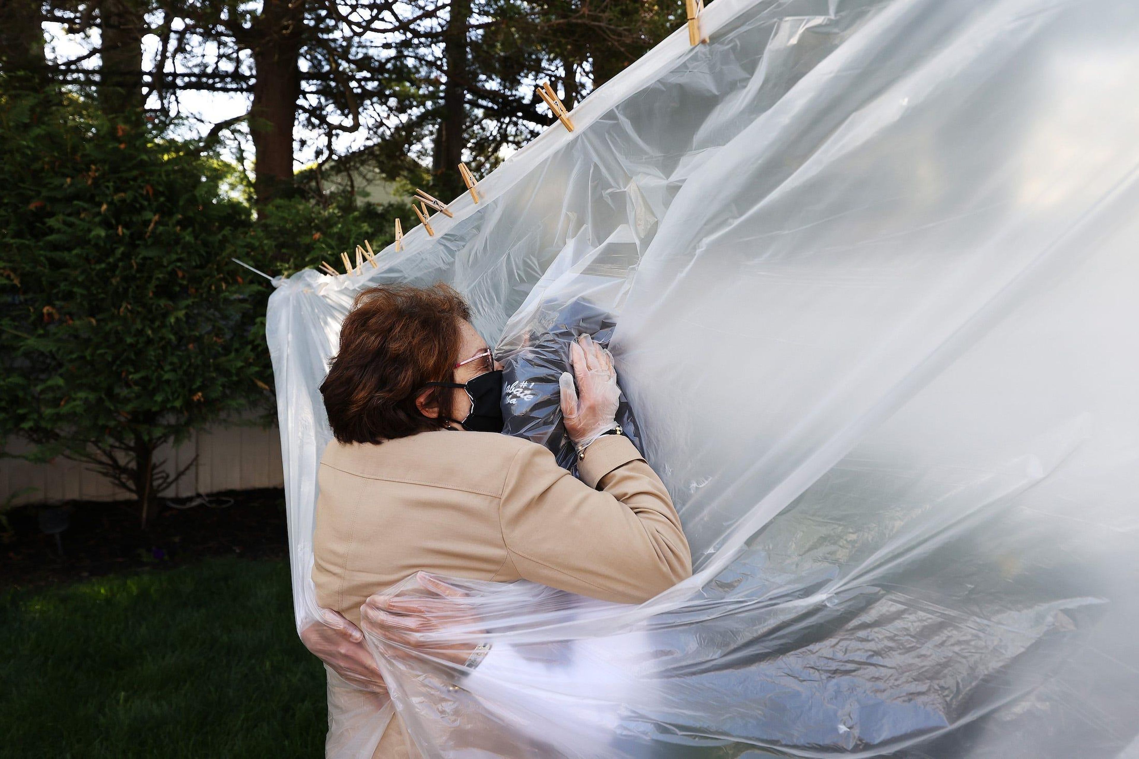 Michelle Grant abrazando a su madre a través de un trozo de plástico en Wantagh, Nueva York.