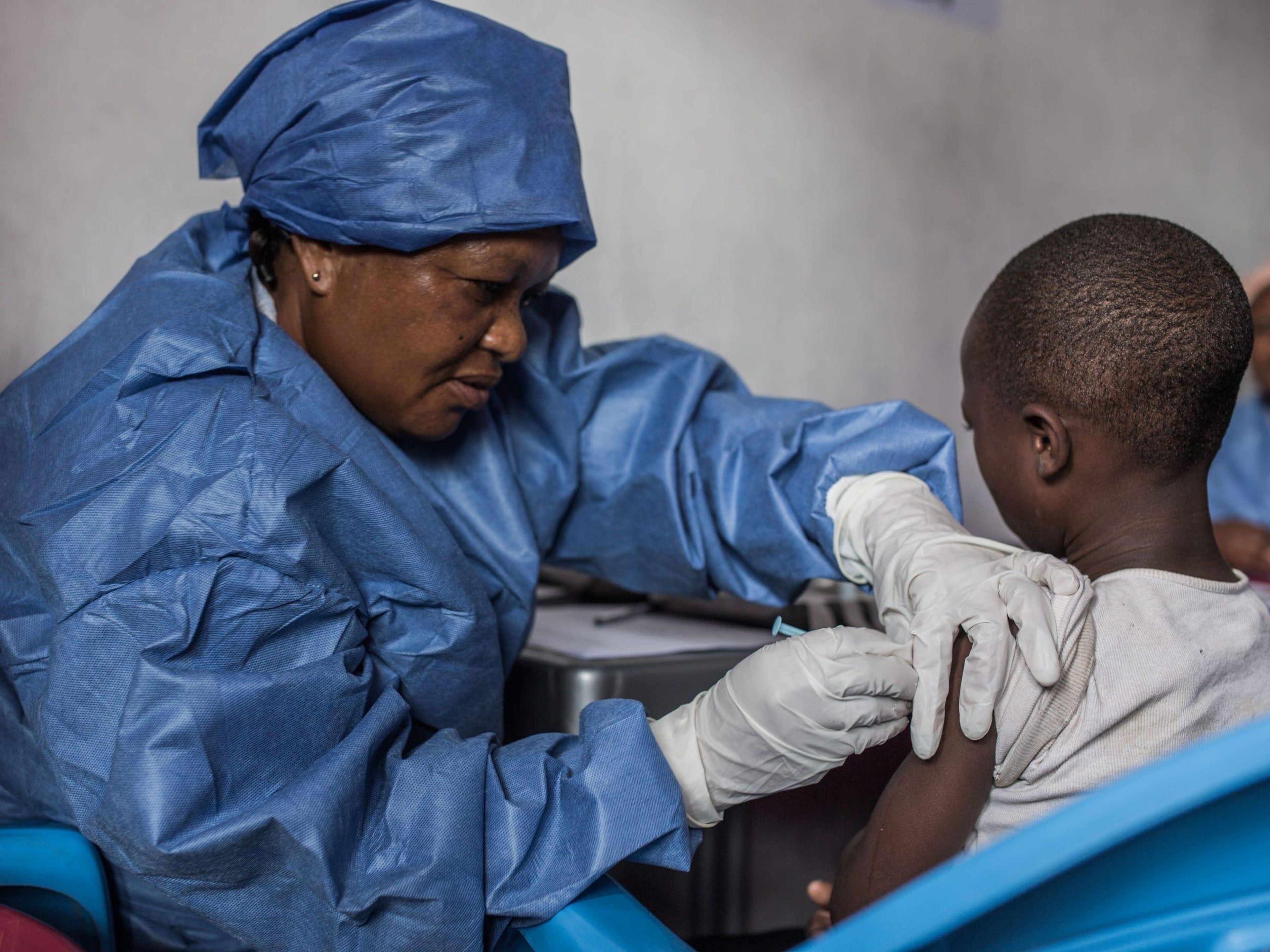 Vacunan a una niña contra el ébola.