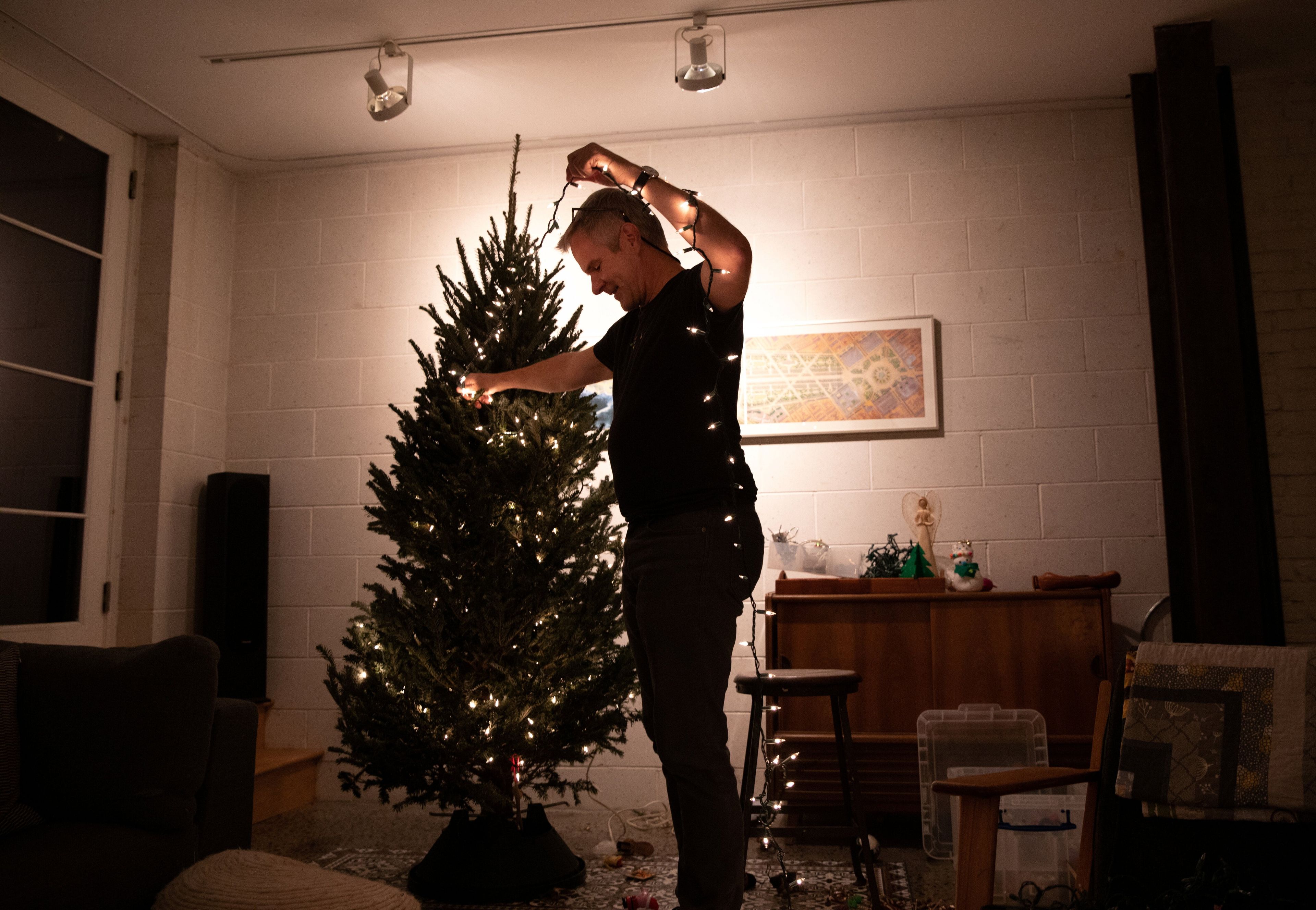Hombre colocando árbol de Navidad