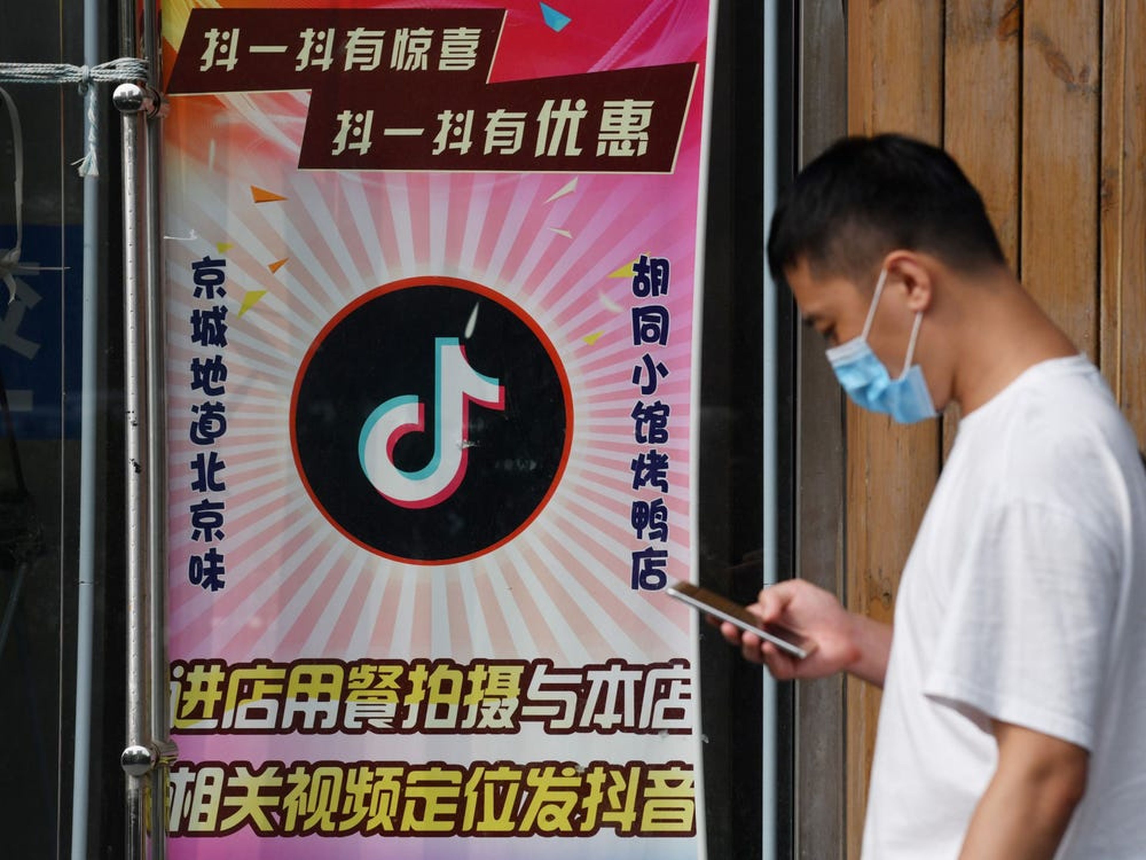 Un hombre pasa junto a un restaurante con un logotipo de TikTok que se muestra en la ventana en Beijing el 14 de septiembre de 2020