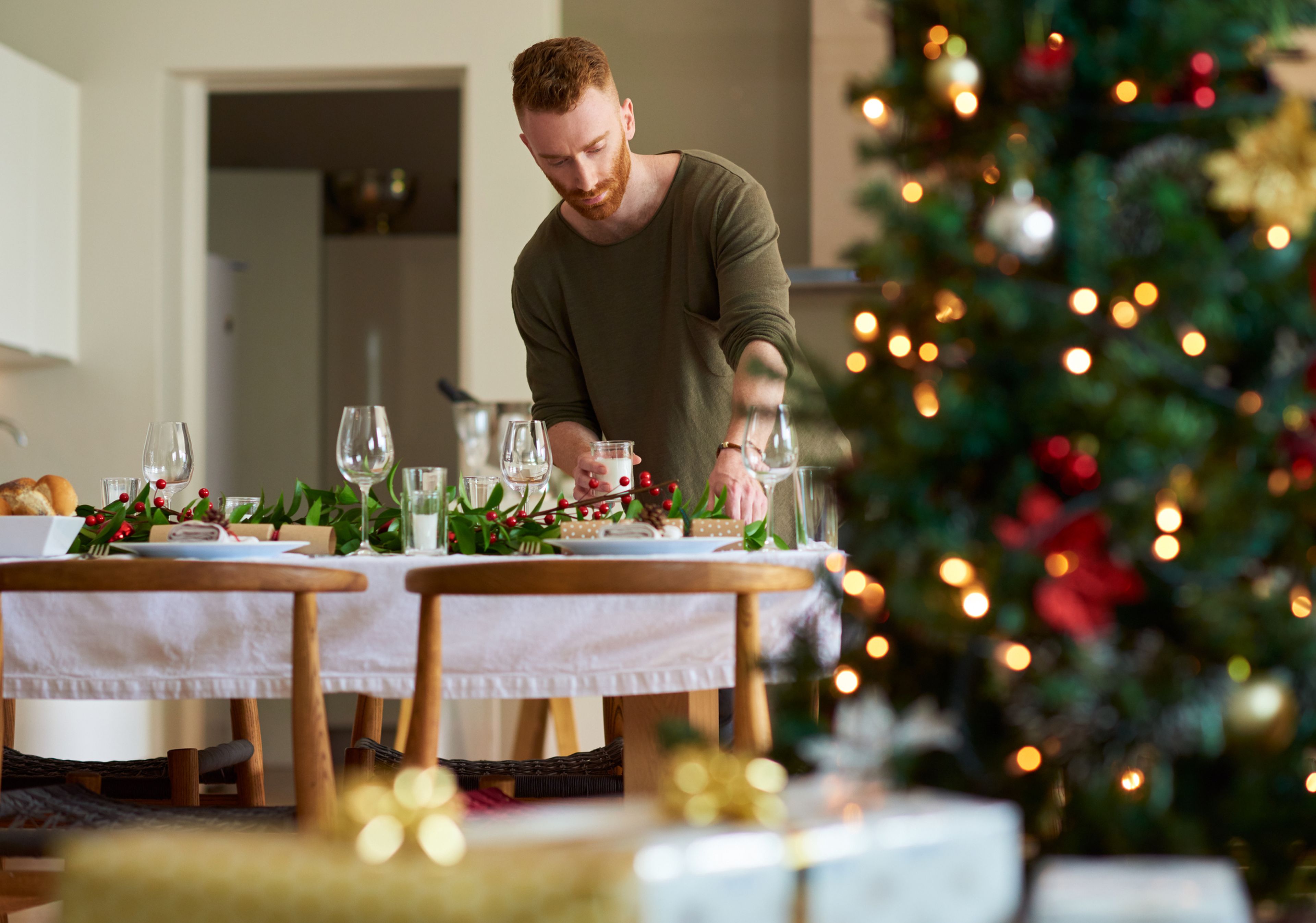 hombre preparando la mesa para Navidad