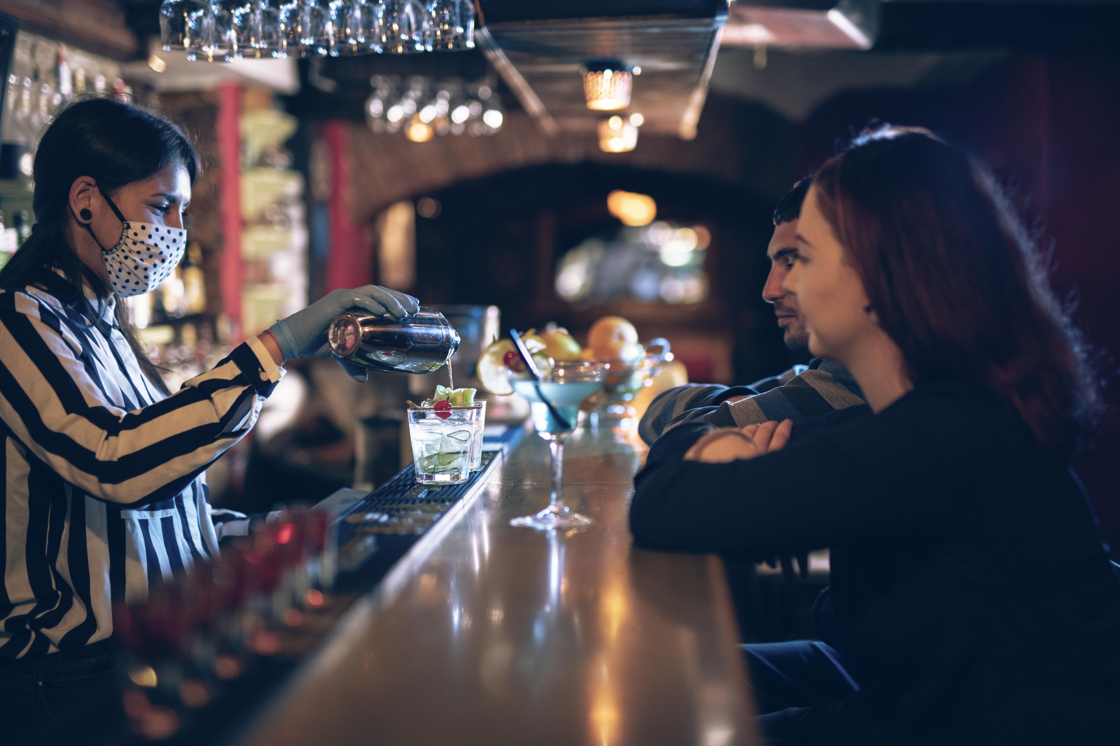 Mujer poniendo copas en un pub