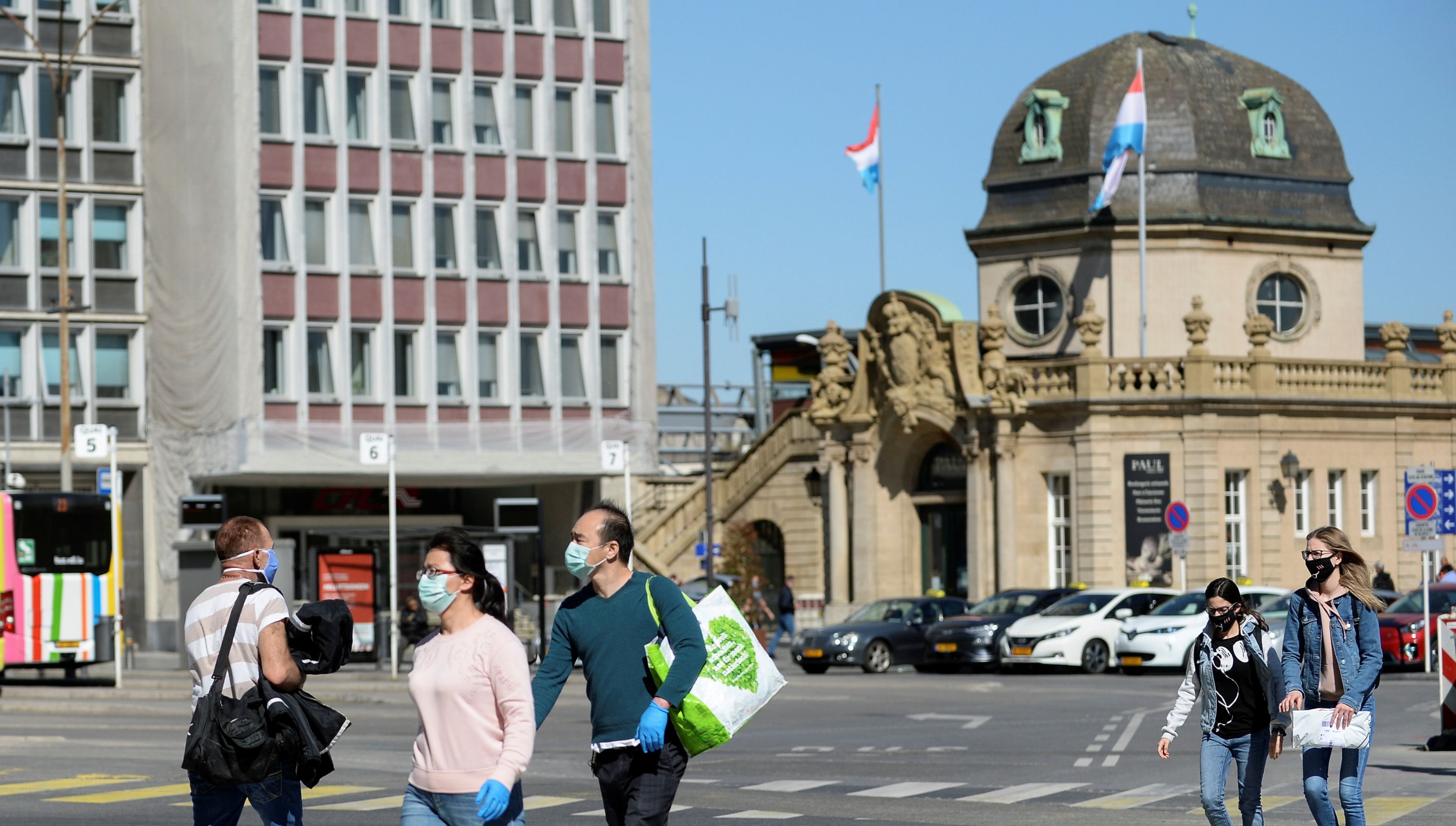 Personas con mascarilla pasan ante la Estación Central de Luxemburgo