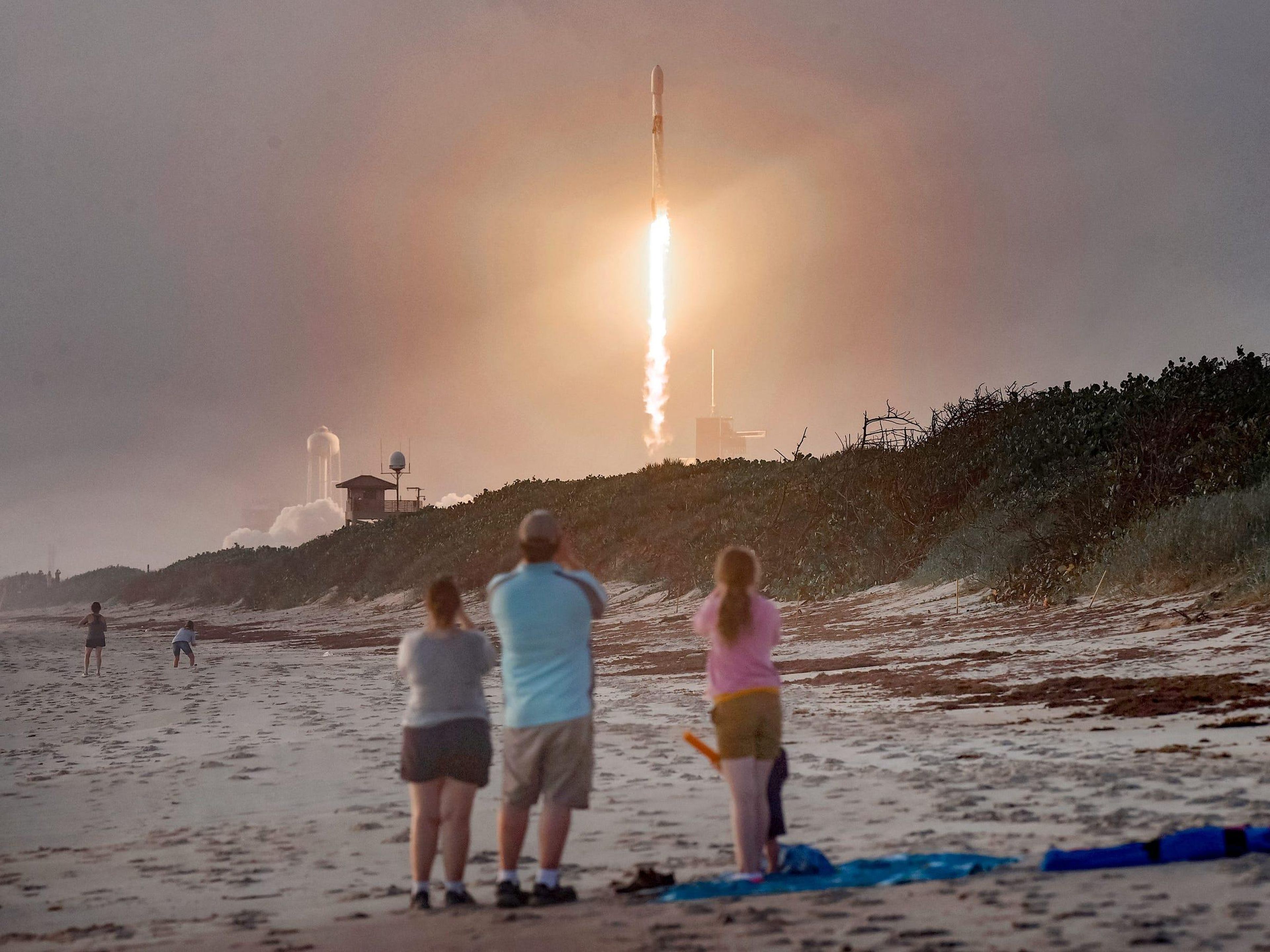 Espectadores viendo cómo un cohete Falcon 9 con 60 satélites Starlink se lanza desde el Centro Espacial Kennedy de la NASA en Cabo Cañaveral, Florida, el 6 de octubre de 2020.