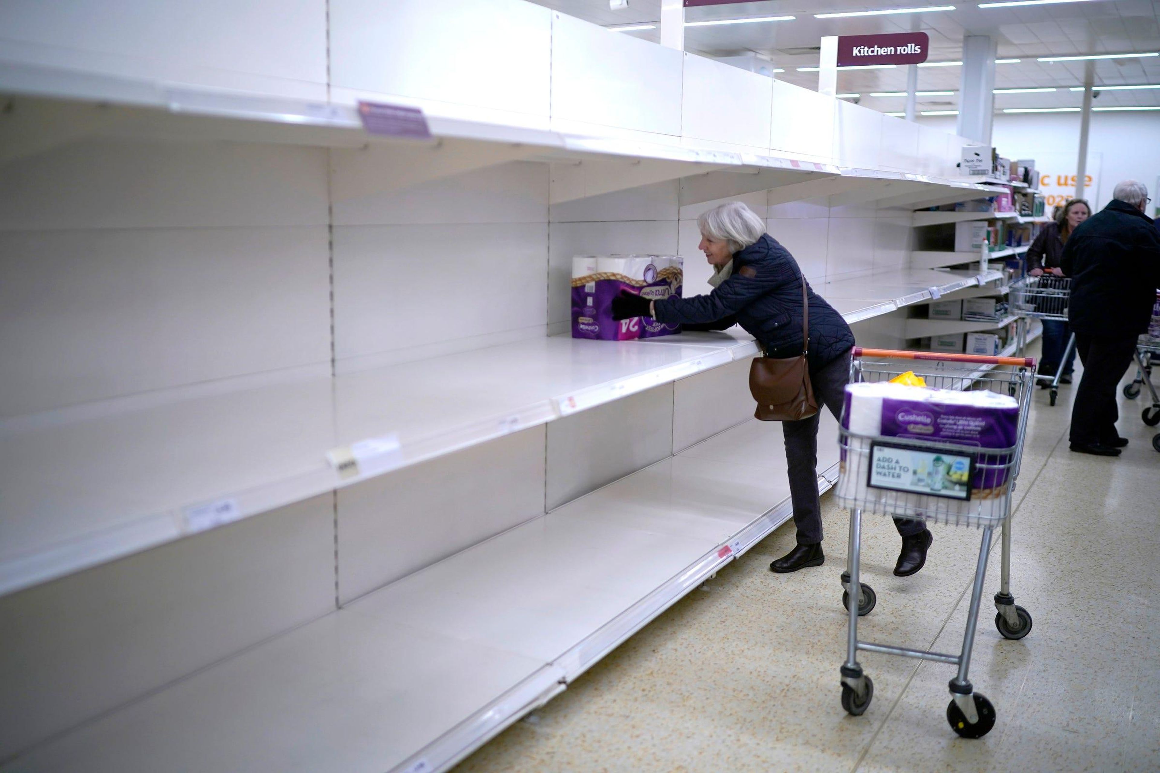 Una persona mayor coge el último paquete de papel higiénico en el supermercado Sainsbury's en Northwich, Reino Unido.