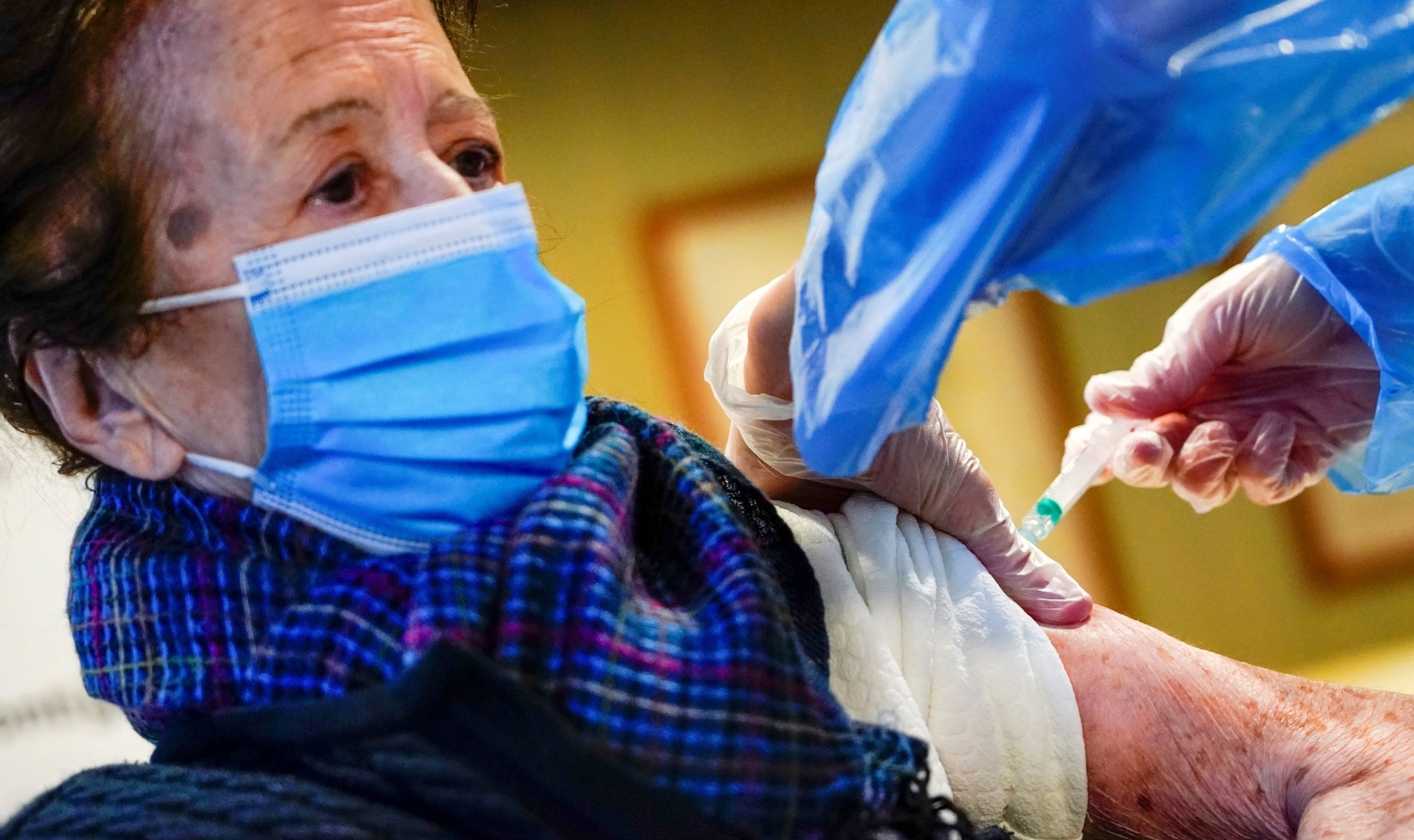 Una anciana recibe una dosis de la vacuna contra el coronavirus en una residencia en Madrid