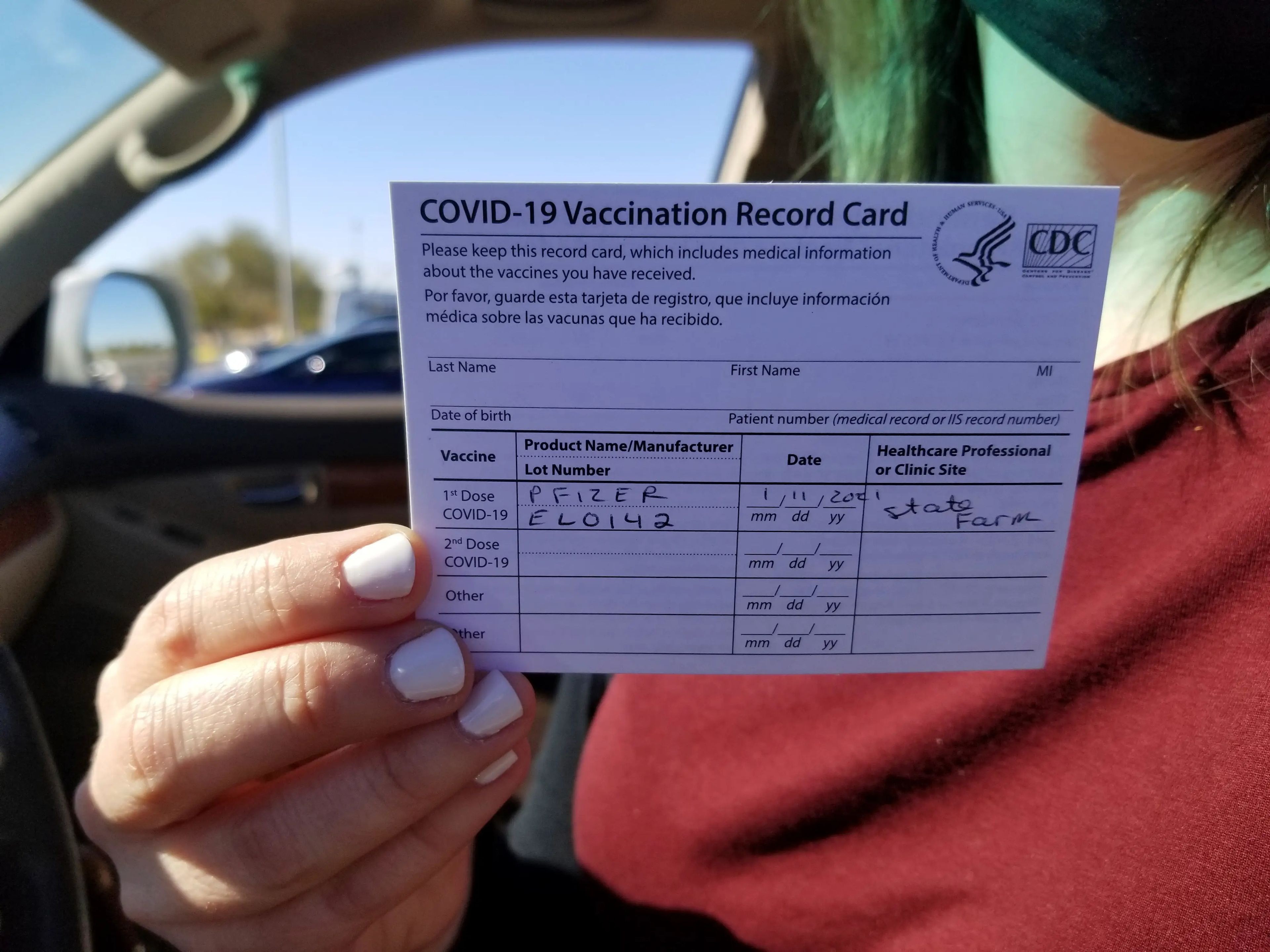 Emily Alexander, de 37 años, muestra su tarjeta de vacunación COVID-19 poco después de recibir la vacuna en State Farm Stadium en Glendale, Arizona, el 11 de enero de 2021.
