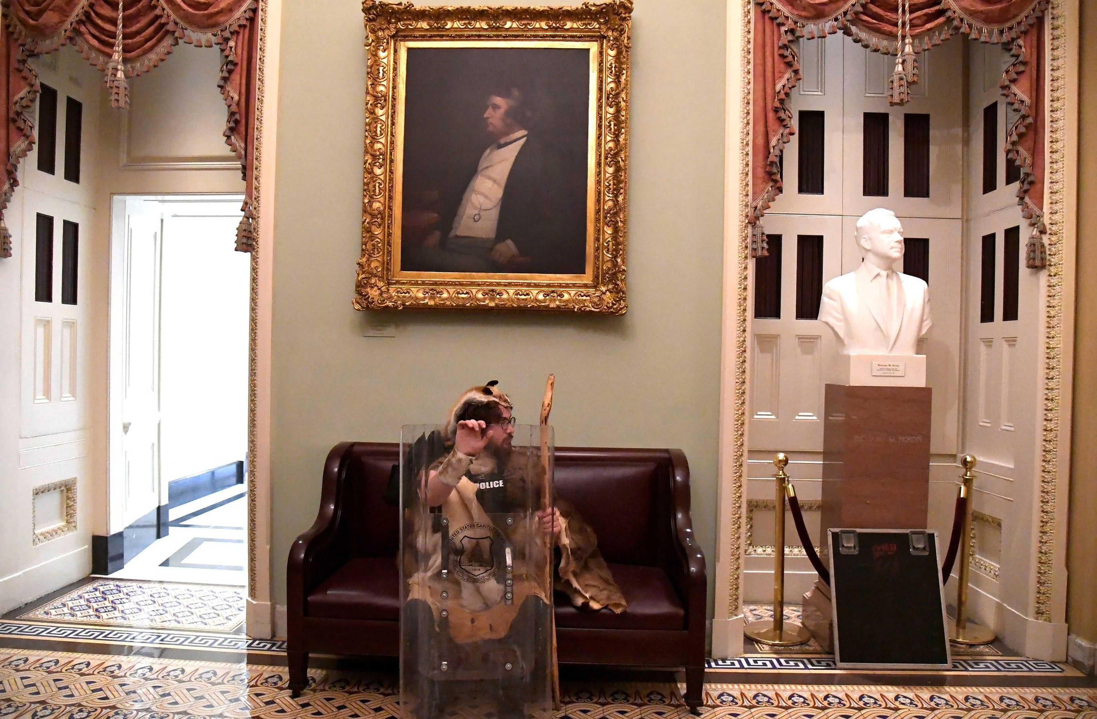 A supporter of President Donald Trump takes a seat away from the action on the second floor of the US Capitol.