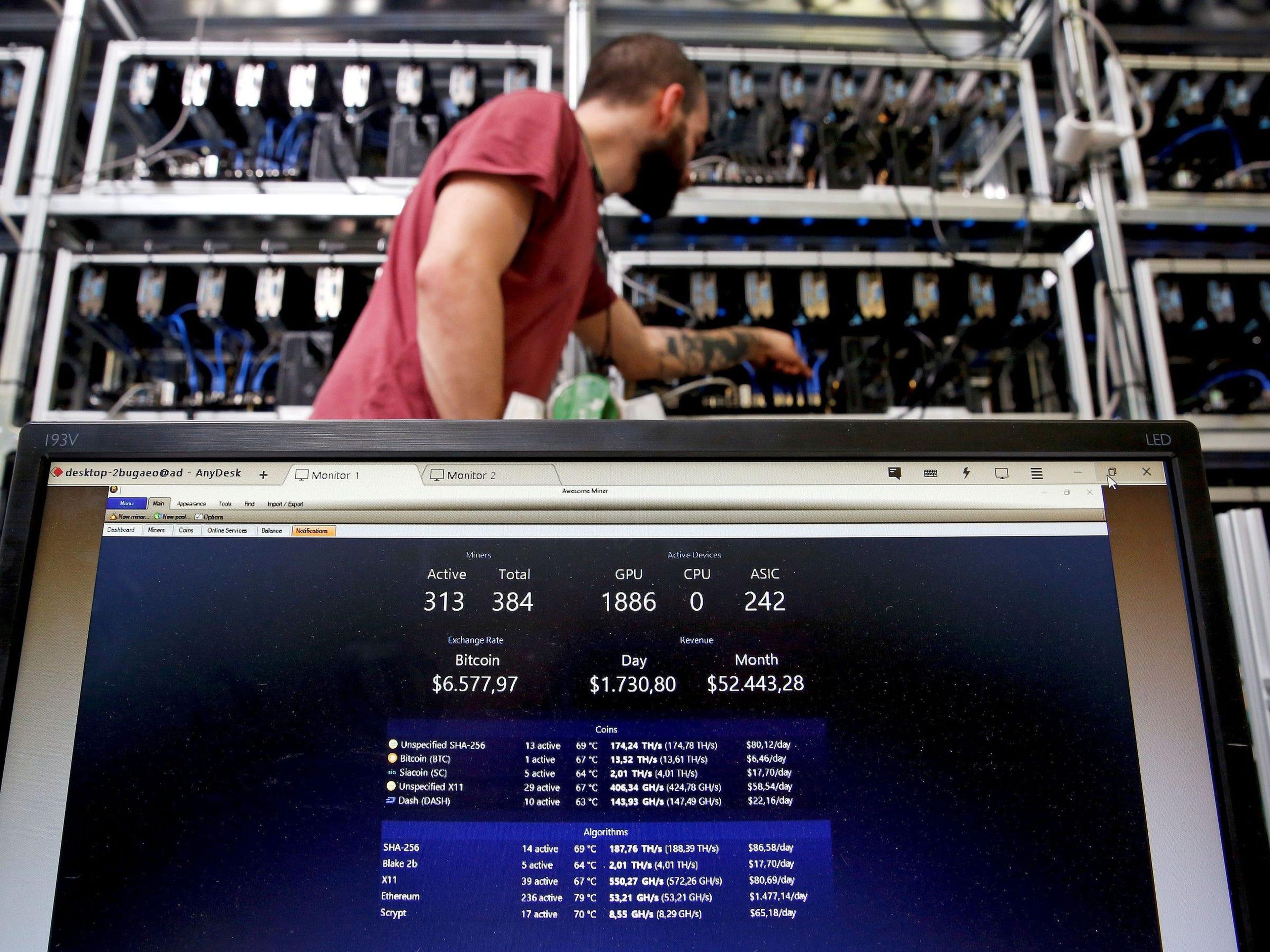 A bitcoin-mining computer and a screen showing bitcoin exchange rates at Bitminer Factory in Florence, Italy.